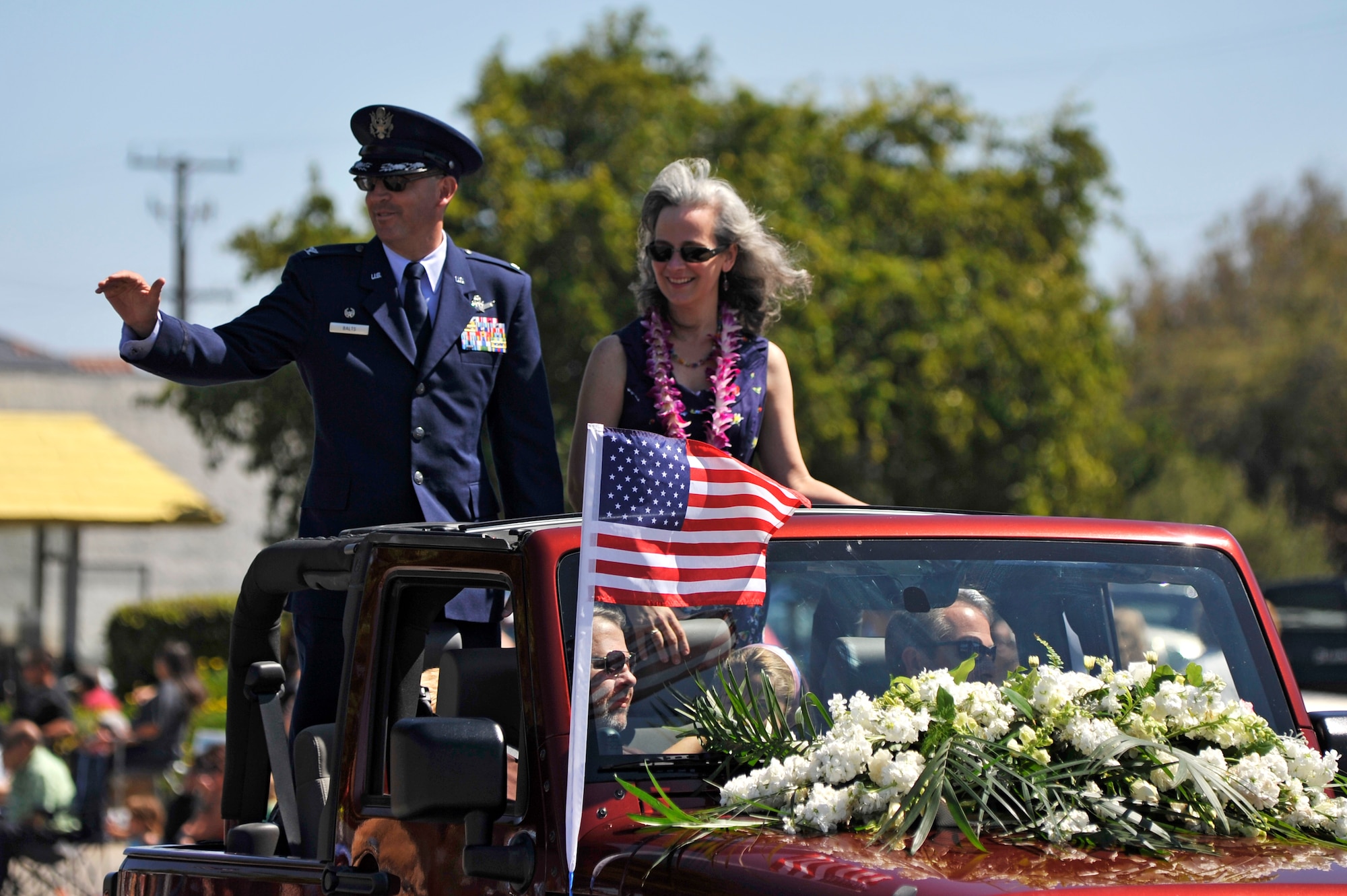 LOMPOC, Calif. -- Col. Keith Balts, 30th Space Wing commander, and wife Christine, wave to spectators during the city of Lompoc's 61st annual Flower Festival Parade on Saturday, June 29. Balts rode in the procession for the parade which was themed "A Salute to the Red, White and Blue". (U.S. Air Force photo/Michael Peterson)