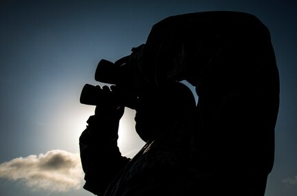 Staff Sgt. Vincent Barnes, 437th Maintenance Group Air Terminal Operation Center controller, looks through a pair of binoculars at the flight line checking on aircraft while in the ATOC, June 25, 2013, at Joint Base Charleston – Air Base, S.C. (U.S. Air Force photo/ Senior Airman Dennis Sloan)