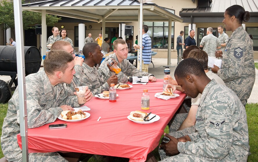 Dorm Residents eat pulled pork barbeque and other fixings as Master Sgt. Shakeera Wright, 436th Medical Support Squadron, speaks to them June 26, 2013, at the Eagle's Net Cafe on Dover Air Force Base, Del. The 436th Airlift Wing staff agencies hosted a home cooked meal for dorm residents. (U.S. Air Force photo/Roland Balik) 

