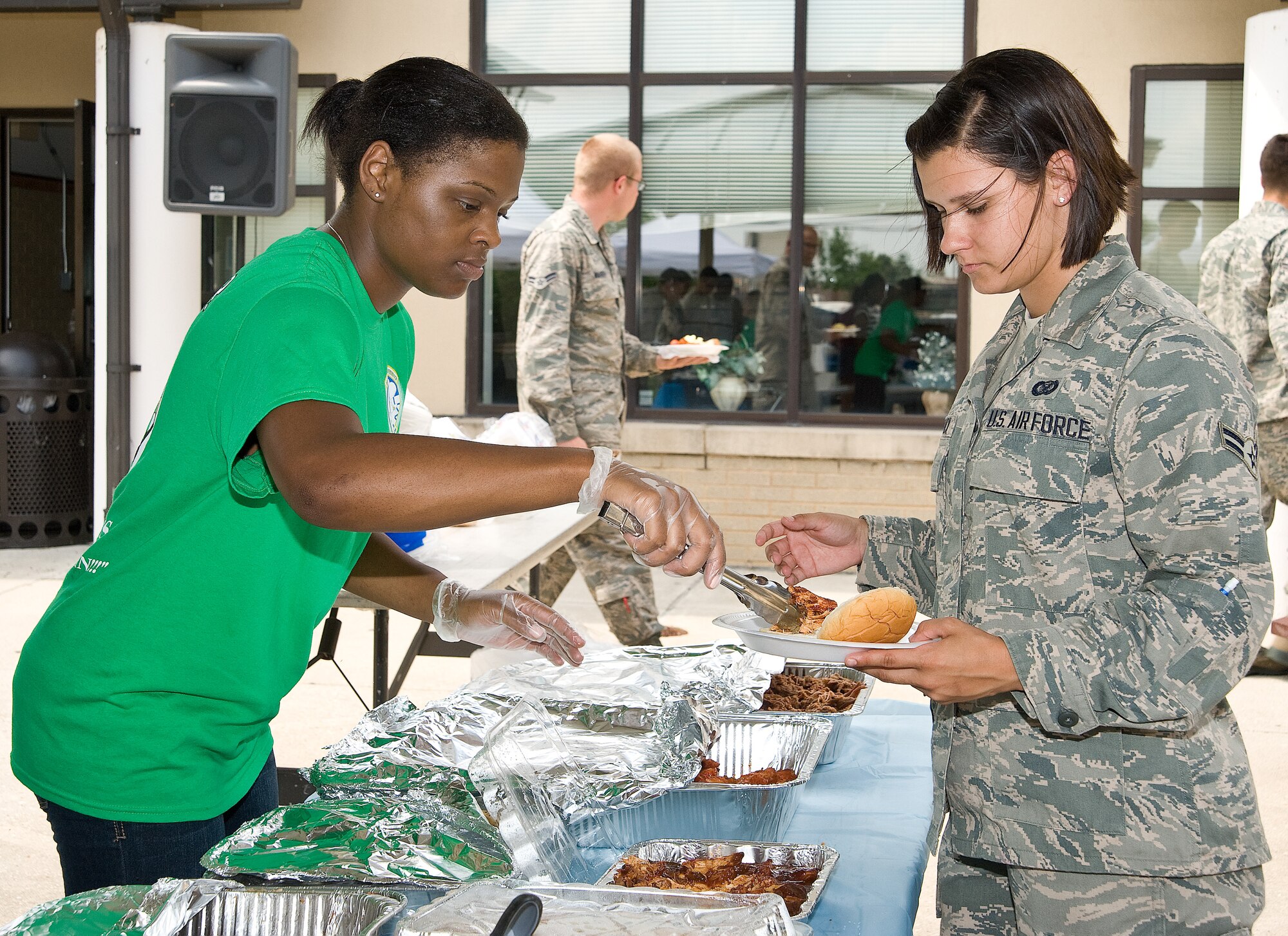 First Lt. Avante Graves, 436th Comptroller Squadron, dishes out pulled pork barbeque to Airman 1st Class Ashlin Federick, 436th AW/Public Affairs photojournalist, June 26, 2013, at the Eagle?s Net Caf? on Dover Air Force Base, Del. The 436th Wing Staff Agencies hosted a home cooked meal for dorm residents. (U.S. Air Force photo/Roland Balik)
