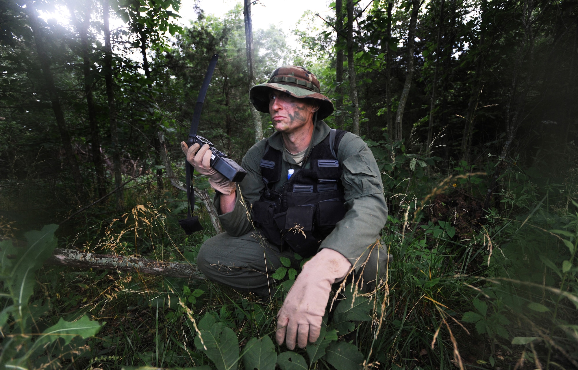 Captain Jason Morgan, 393rd Bomb Squadron B-2 Spirit pilot, radios in his location prior to his rescue during survival training, Whiteman Air Force Base, Mo., June 27, 2013. The training consisted of evading enemies after landing on the ground. Pilots followed the instructor from point-to-point to learn how to gather materials; seek shelter; discard unnecessary supplies without leaving behind clues of their presence; find food; use maps, radios, and flares; and safely be retrieved by friendly forces. (U.S. Air Force photo by Staff Sgt. Alexandra M. Boutte/Released)