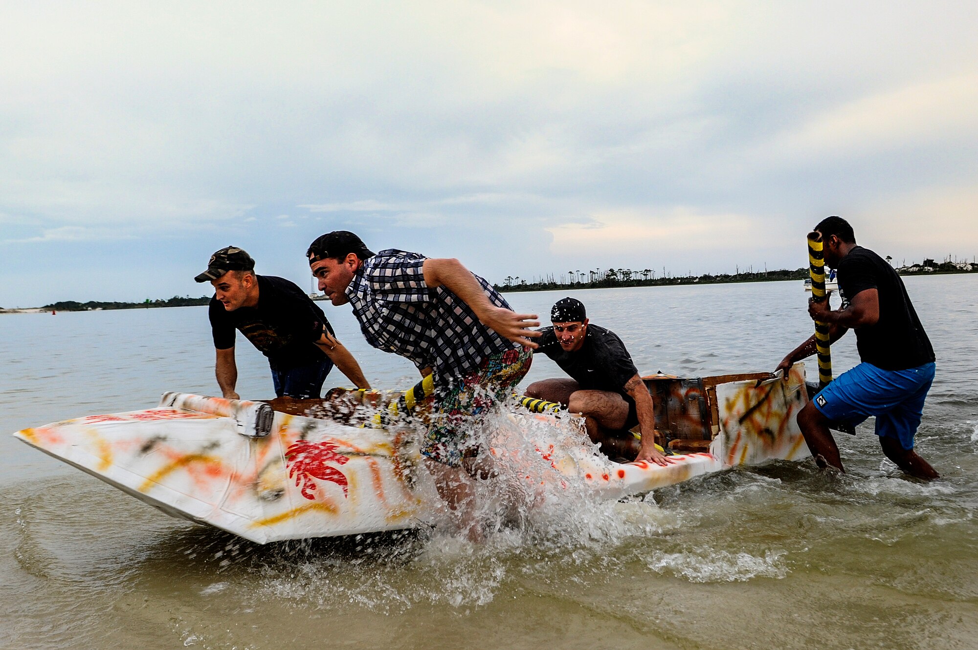 Air Commandos from the 823rd Rapid Engineer Deployable Heavy Operational Repair Squadron Engineer, pull their cardboard boat past the finish line during the 25th cardboard boat regatta at the Soundside Marina on Hurlburt Field, Fla., June 28, 2013. The 823rd RHS stole the title as regatta champions from the 1st Special Operations Equipment Maintenance Squadron, the defending champions. (U.S. Air Force photo/Airman 1st Class Christopher Callaway) 