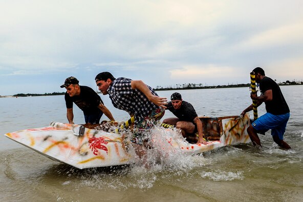 Air Commandos from the 823rd Rapid Engineer Deployable Heavy Operational Repair Squadron Engineer, pull their cardboard boat past the finish line during the 25th cardboard boat regatta at the Soundside Marina on Hurlburt Field, Fla., June 28, 2013. The 823rd RHS stole the title as regatta champions from the 1st Special Operations Equipment Maintenance Squadron, the defending champions. (U.S. Air Force photo/Airman 1st Class Christopher Callaway) 