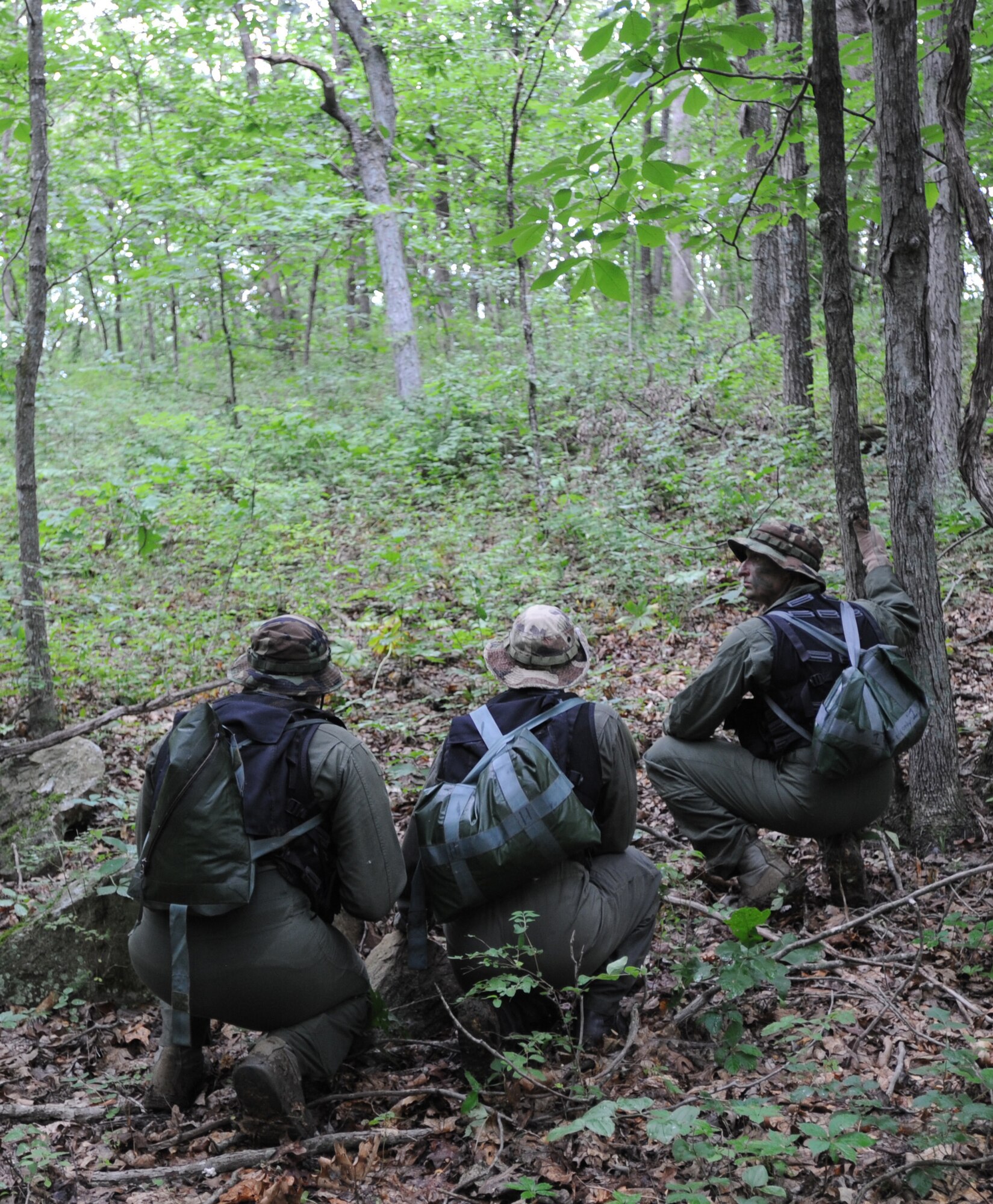 Three B-2 Spirit pilots from Whiteman Air Force Base, Mo., kneel down as they hear movement from aggressors during survival training, Whiteman Air Force Base, Mo., June 27, 2013. Instructors conduct the training to refresh aircrew’s skill sets and update them on new techniques, procedures and technologies. (U.S. Air Force photo by Staff Sgt. Alexandra M. Boutte/Released)