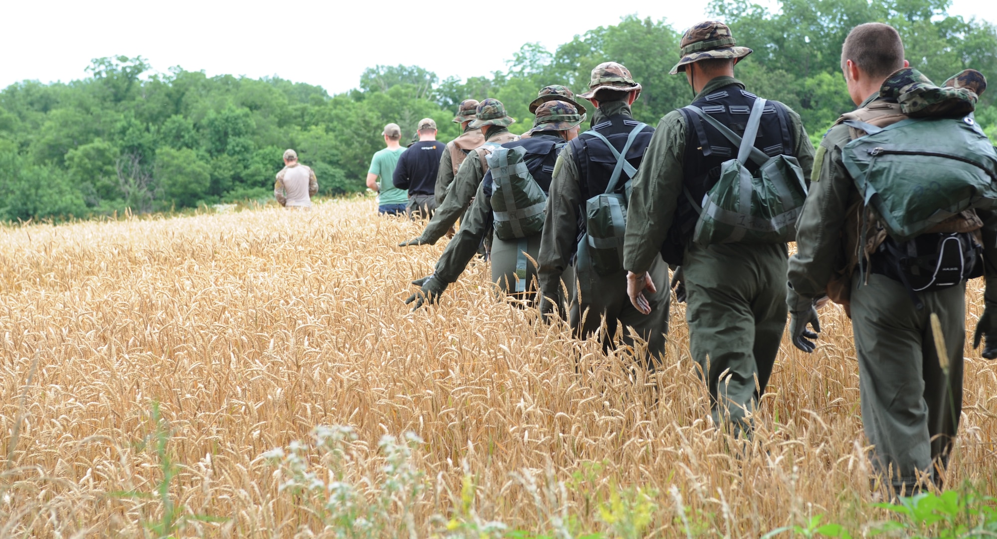 Seven B-2 Spirit pilots from Whiteman Air Force Base, Mo., follow a survival, evasion, resistance and escape (SERE) specialist into an open field during survival training around Whiteman Air Force Base, Mo., June 27, 2013. Aircrew must complete this training once every three years; in addition to the 19-day initial survival training they receive early in their careers. (U.S. Air Force photo by Staff Sgt. Alexandra M. Boutte/Released)