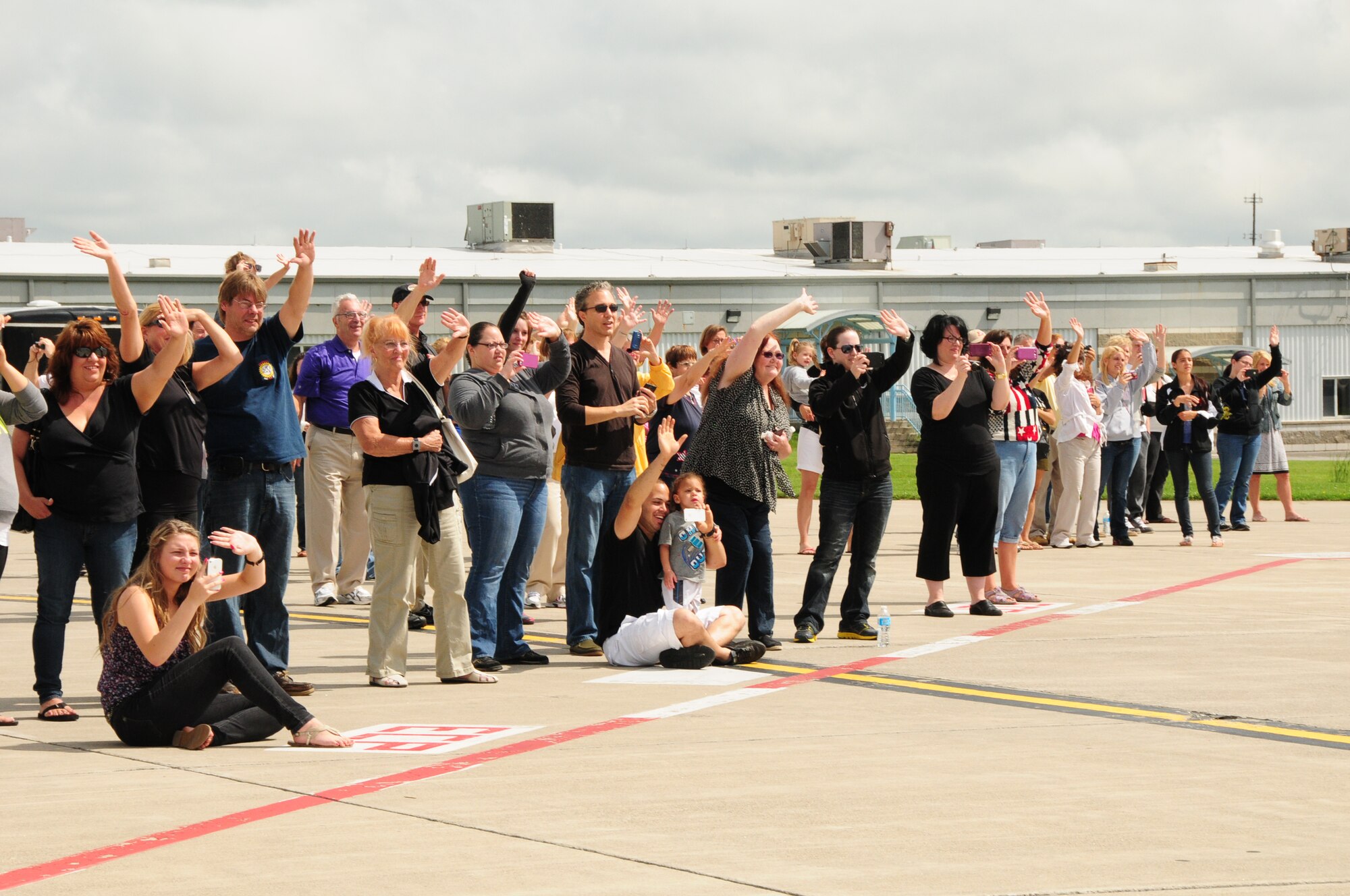 Family and friends of the 107th Airlift Wings members wave good bye as the C-130 departs the Niagara Falls Reserve Station as they deploy to Southwest Asia on June 29, 2013. (Air National Guard Photo/Senior Master Sgt. Ray Lloyd)