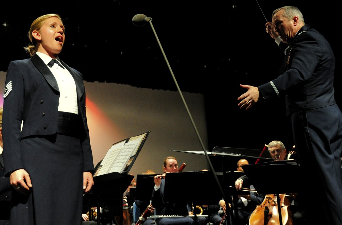Col. Larry Lang, conductor for the U.S. Air Force Band, and Tech. Sgt. Amanda Harper, Singing Sergeant soprano vocalist, perform during The U.S. Air Force Band Alumni Reunion Concert at West Potomac High School in Alexandria, Va., June 29, 2013. The three-day reunion allowed former members and conductors to participate in several performances and events with current bandsmen. (U.S. Air Force photo/Airman 1st Class Erin O’Shea) 