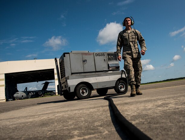 Senior Airman Clayton Valentine, 437th Maintenance Group jet-propulsion specialist, walks toward a C-17 Globemaster III after setting up a generator to be used during  a routine engine check June 26, 2013, at Joint Base Charleston – Air Base, S.C. Airmen from the 437th MXG perform routine maintenance to  C-17s daily. (U.S. Air Force photo/ Senior Airman Dennis Sloan)