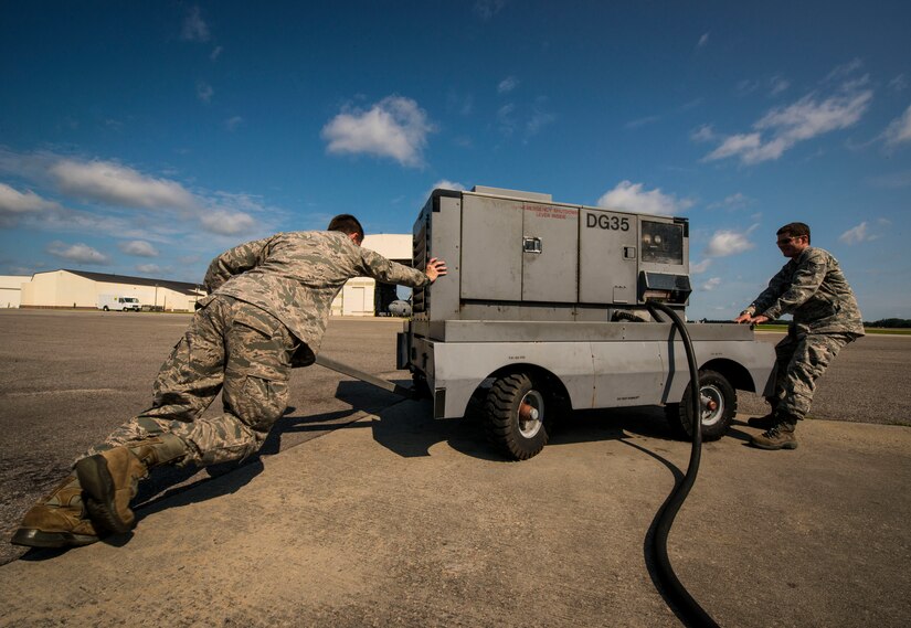 Tech. Sgt. Jonathan Livingston and Senior Airman Clayton Valentine, 437th Maintenance Group jet-propulsion specialists, move a generator into place before hooking it up to a C-17 Globemaster III during a routine engine check June 26, 2013, at Joint Base Charleston – Air Base, S.C. Airmen from the 437th MXG perform routine maintenance to  C-17s daily.  (U.S. Air Force photo/ Senior Airman Dennis Sloan)
