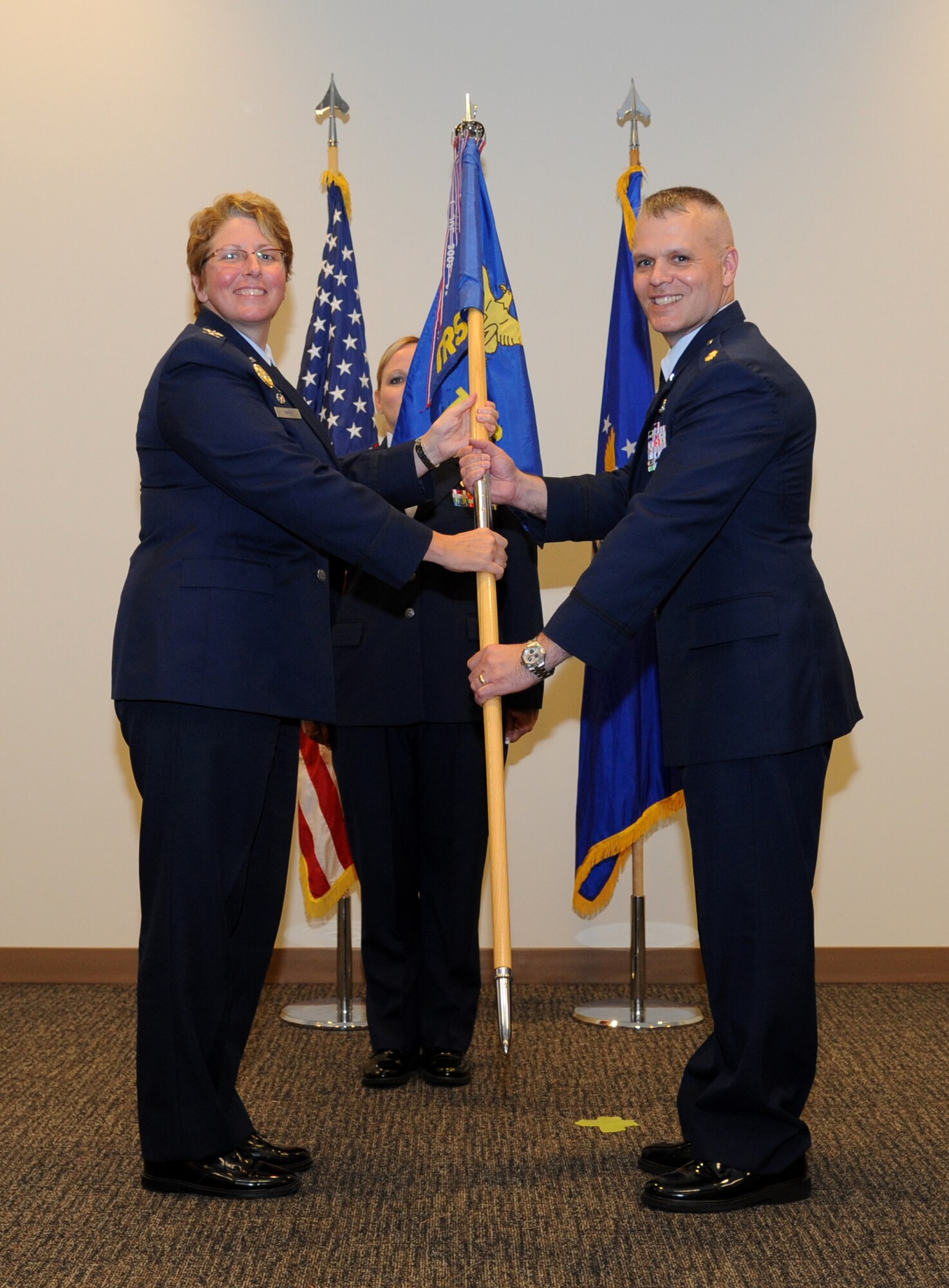 Col. Maureen Smith, 81st Training Group commander, passes the guidon to Maj. Kevin Bray as he assumes command of the 334th Training Squadron during a change of command ceremony June 28, 2013, at the Roberts Consolidated Maintenance Facility, Keesler Air Force Base, Miss.  Lt. Col. Jeffrey McLemore was the outgoing 334th TRS commander.  (U.S. Air Force photo by Kemberly Groue)