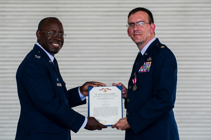 Col. Dennis Dabney, 437th Maintenance Group commander, presents Maj. Matthew Manns, 437th Maintenance Operations Squadron commander, the Meritorious Service Medal certificate during the 437th Maintenance Operations Squadron inactivation ceremony June 28, 2013, at Joint Base Charleston – Air Base, S.C. The 437th MOS was activated in October 2002. (U.S. Air Force photo/ Senior Airman George Goslin)