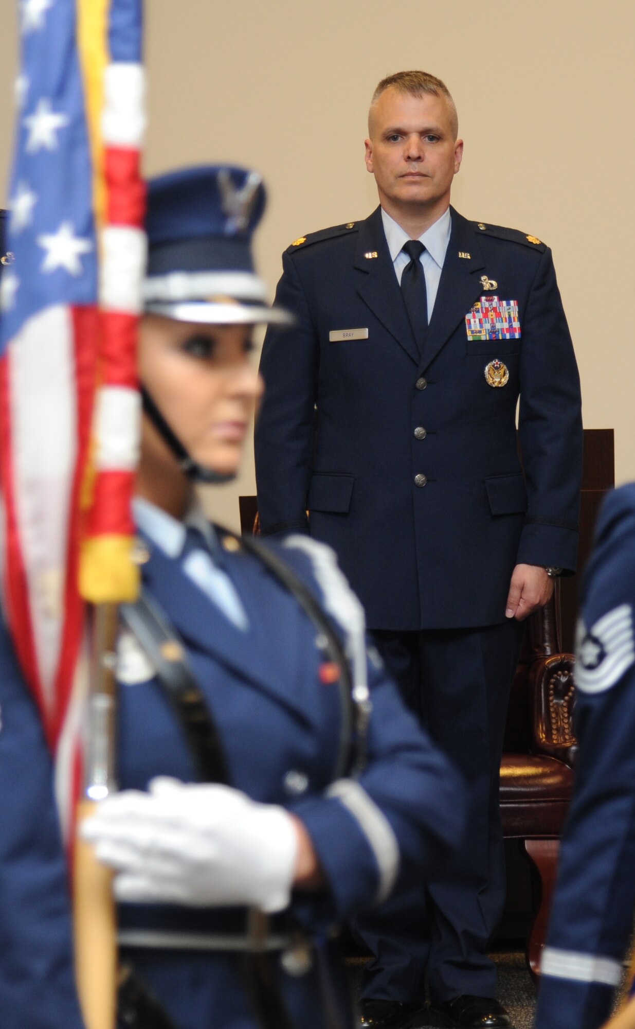 Maj. Kevin Bray, incoming 334th Training Squadron commander, stands at attention as members of the Keesler Honor Guard post the colors during the 334th TRS change of command ceremony June 28, 2013, at the Roberts Consolidated Maintenance Facility, Keesler Air Force Base, Miss.  Col. Maureen Smith, 81st Training Group commander, was the presiding officer for the event and Lt. Col. Jeffrey McLemore was the outgoing 334th TRS commander.  (U.S. Air Force photo by Kemberly Groue)