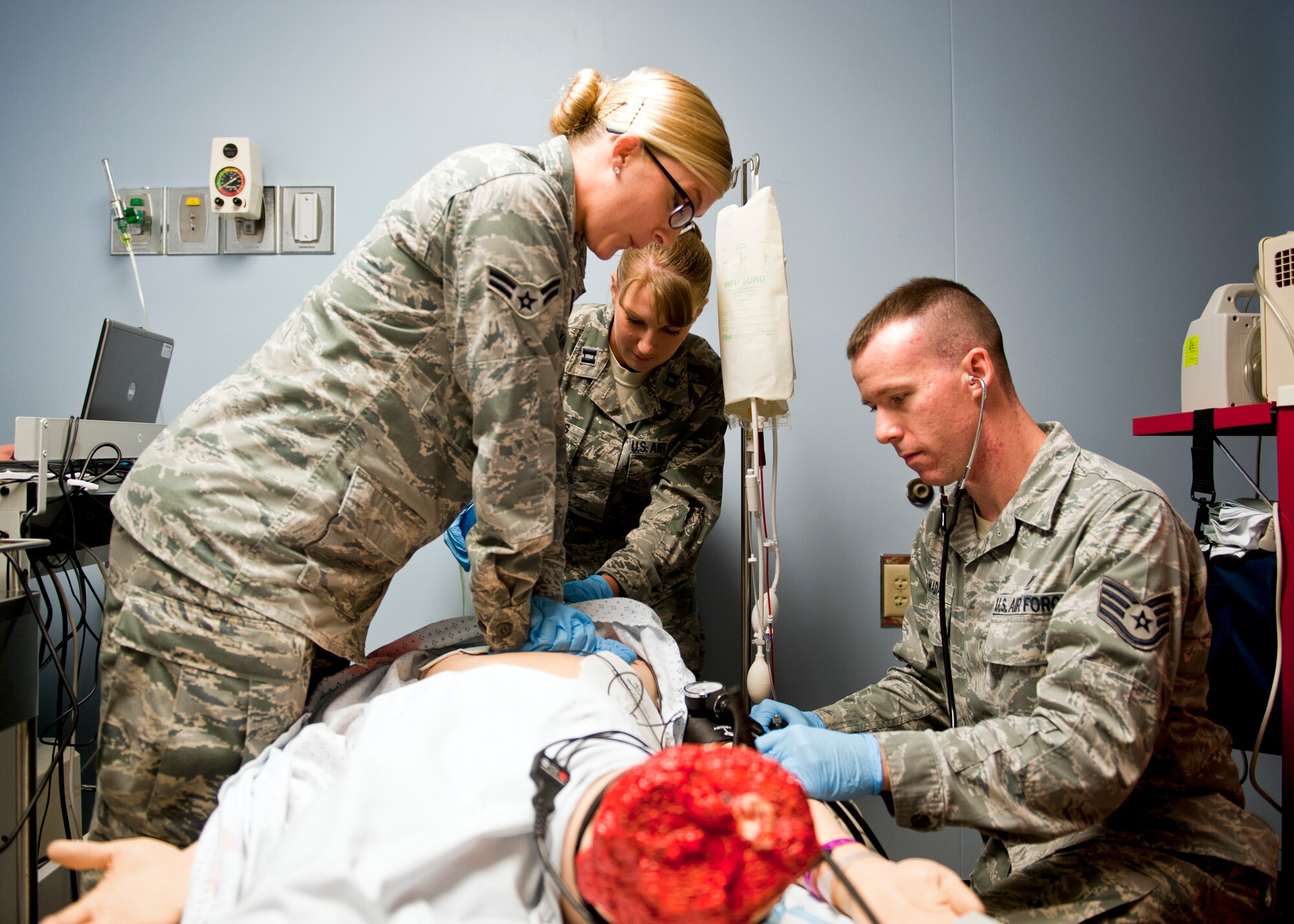 39th Medical Operations Squadron members Airman 1st Class Valerie Essman, ambulance serviceman, Capt. Rachel Rhodes, clinical nurse, and Staff Sgt. Jeremy Canady, medical technician, perform emergency care on a Sim Man medical dummy June 19, 2013, at Incirlik Air Base, Turkey. The Sim Man is capable of simulating various traumas for training purposes. (U.S. Air Force photo by Senior Airman Daniel Phelps/Released)