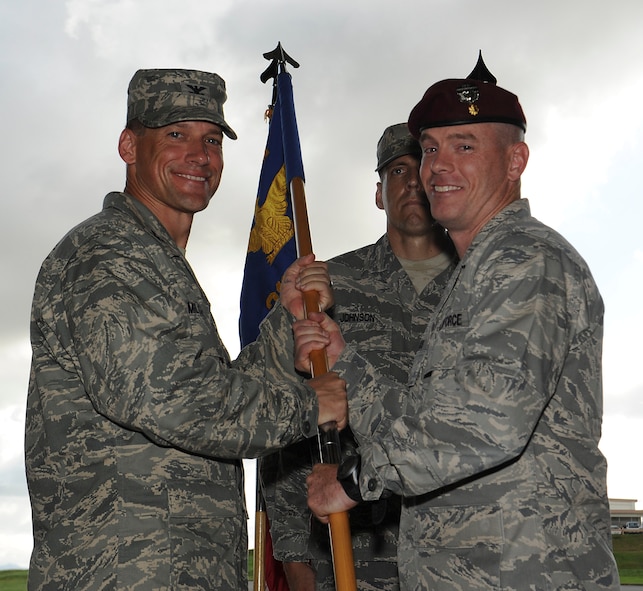 U.S. Air Force Col. Peter Milohnic, 18th Operations Group commander, passes the guidon to Maj. Charles Bris-bois, 31st Rescue Squadron commander, during a change of command ceremony on Kadena Air Base, Japan, July 2, 2013. The 31st RQS trains, equips and employs combat-ready pararescue specialists. The pararescuemen are experts in medical care and small-unit tactics providing survivor contact, treatment and extraction during combat rescue operations in hostile or denied territory. (U.S. Air Force photo by Airman 1st Class Malia Jenkins/Released) 
