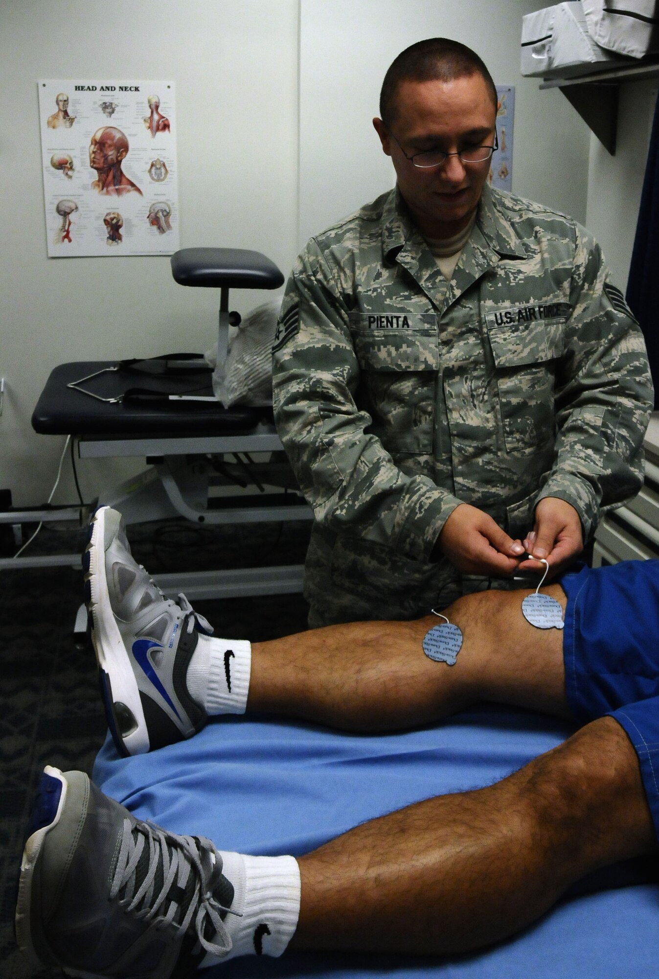 Staff Sgt. David Pienta, 36th Medical Operations Squadron physical medicine technician, connects neuromuscular electrical stimulation pads, which is one tool the clinic uses to relieve muscle pain, for a physical therapy patient on Andersen Air Force Base, Guam, July 2, 2013. The physical therapy clinic, located at the Coral Reef Fitness Center, serves approximately 23 patients a day to improve the quality of life for individuals who are experiencing discomfort as a result of chronic or acute musculoskeletal pain or impact injuries and in need of quality health care. (U.S. Air Force photo by Airman 1st Class Mariah Haddenham/Released)