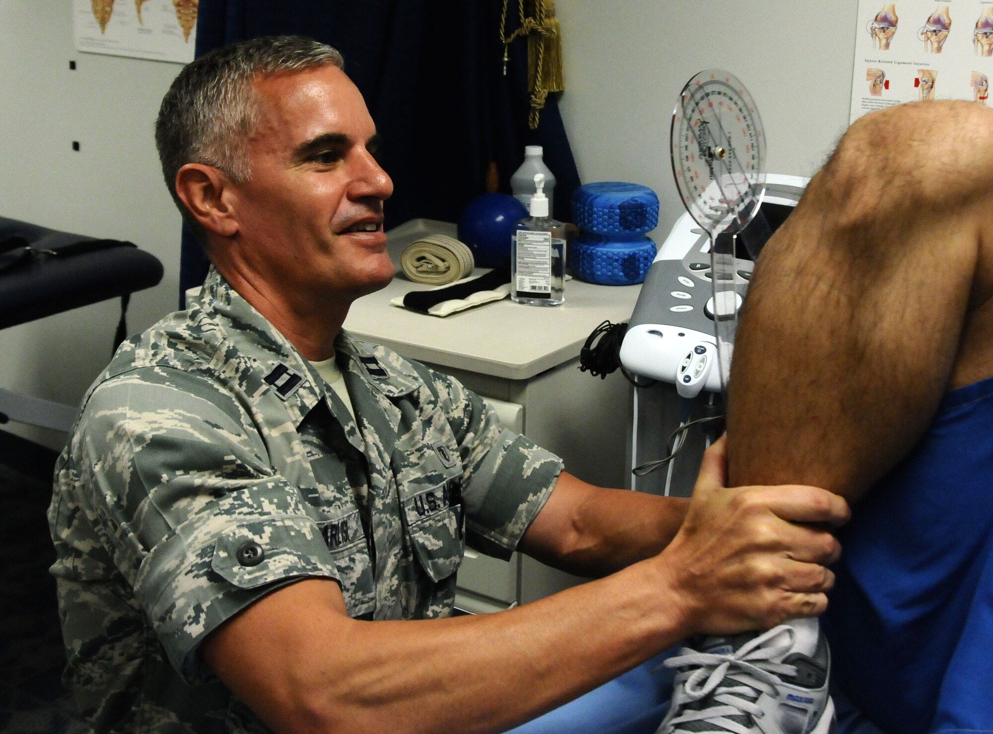 Capt. William Garlisi, 36th Medical Operations Squadron physical therapy officer in charge, measures a patient’s range of motion on Andersen Air Force Base, Guam, July 2, 2013. A physical therapist evaluates a patient and passes the treatment program to the technicians who administer it to the patient, ensuring they are educated about the cause of their condition. (U.S. Air Force photo by Airman 1st Class Mariah Haddenham/Released)