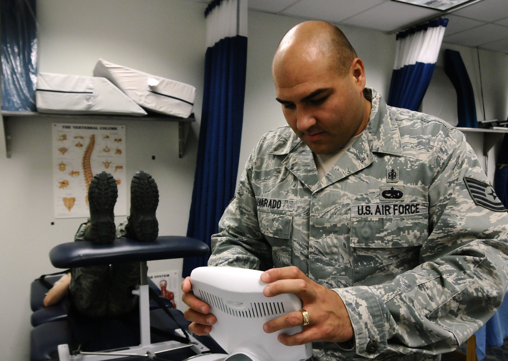 Tech Sgt. Robert Alvarado, 36th Medical Operations Squadron NCO in charge of physical therapy, programs a lumbar traction table for a patient on Andersen Air Force Base, Guam, July 2, 2013. Using this table is a method for treating lower back and neck pain. The physical therapy clinic, located at the Coral Reef Fitness Center, serves approximately 23 patients per day to improve the quality of life for individuals who are experiencing discomfort as a result of chronic or acute musculoskeletal pain or impact injuries and in need of quality health care. (U.S. Air Force photo by Airman 1st Class Mariah Haddenham/Released)