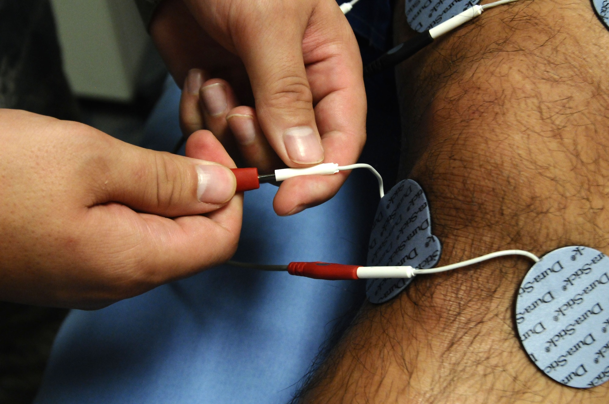 Staff Sgt. David Pienta, 36th Medical Operations Squadron physical medicine technician, connects neuromuscular electrical stimulation pads, which is one tool used the clinic uses to relieve muscle pain, for a physical therapy patient on Andersen Air Force Base, Guam, July 2, 2013. The physical therapy clinic, located at the Coral Reef Fitness Center, serves approximately 23 patients per day to improve the quality of life for individuals who are experiencing discomfort as a result of chronic or acute musculoskeletal pain or impact injuries and in need of quality health care. (U.S. Air Force photo by Airman 1st Class Mariah Haddenham/Released)