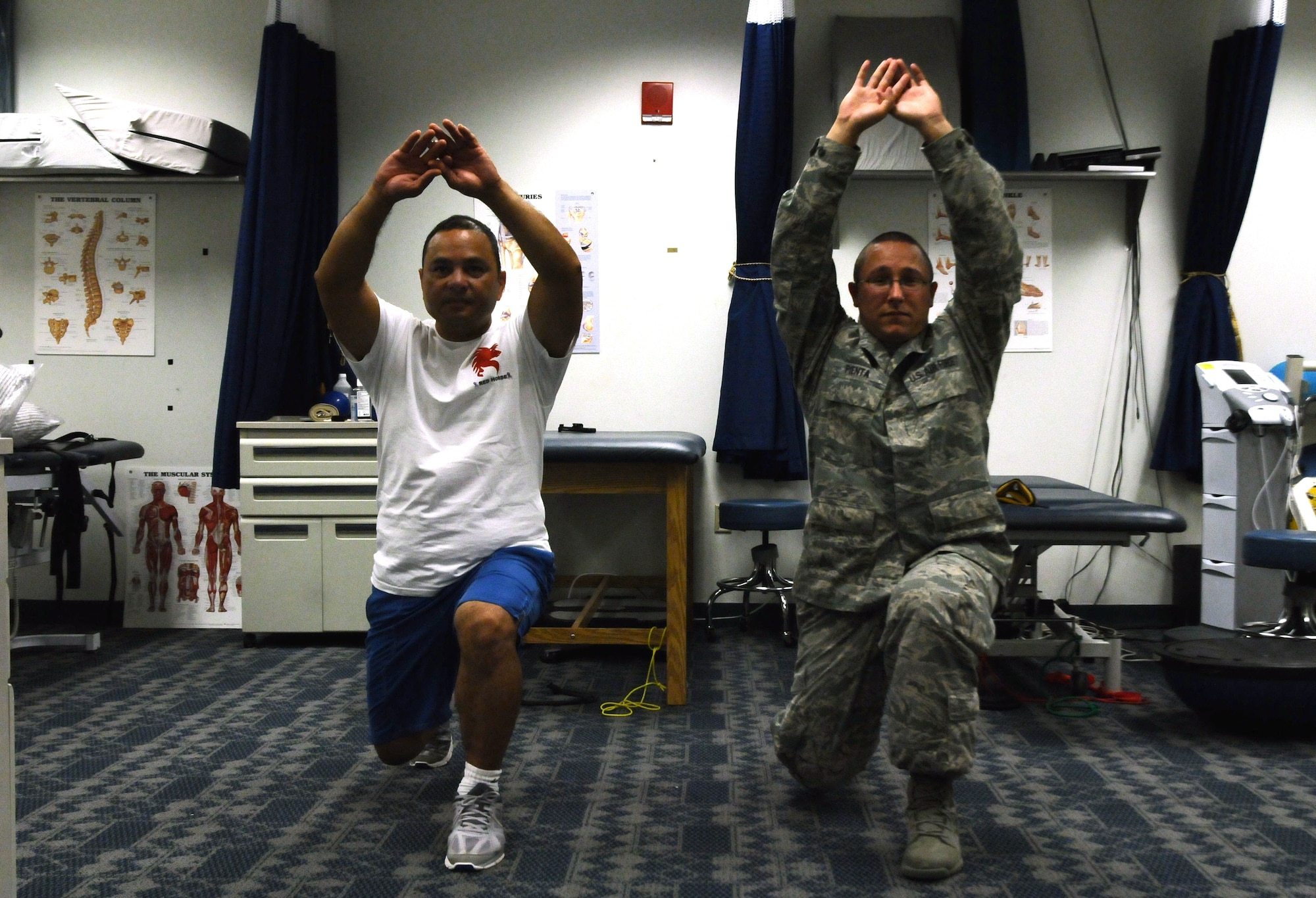 Staff Sgt. David Pienta, 36th Medical Operations Squadron physical medicine technician, guides Master Sgt. Gary Toves, 554th RED HORSE Squadron electrical superintendent, through a physical therapy exercise on Andersen Air Force Base, Guam, July 2, 2013. A physical therapist evaluates a patient and passes the treatment program to the technicians who administer it to the patient, ensuring they are educated about the cause of their condition. (U.S. Air Force photo by Airman 1st Class Mariah Haddenham/Released)