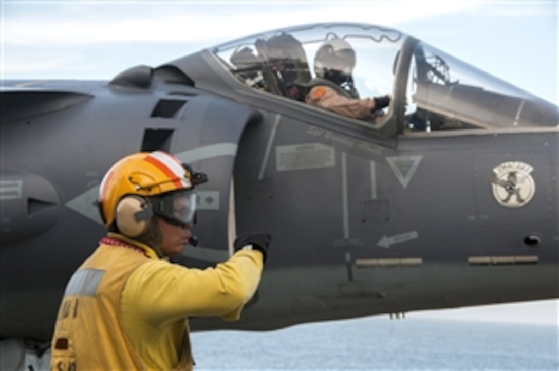 U.S. Navy Petty Officer 1st Class Jesse Seagrave signals to pilot of a AV-8B Harrier jet during flight operations on the amphibious assault ship USS Wasp (LHD 1) in the Atlantic Ocean on June 24, 2013.  The Wasp is conducting flight deck qualifications in preparation for joint strike fighter developmental testing.  The Harrier is assigned to Marine Attack Squadron 223.  