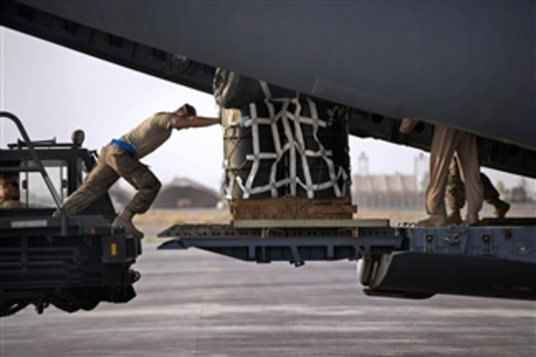 A U.S. Air Force airman pushes a pallet of cargo into a C-17A Globemaster III at Kandahar Airfield in Afghanistan on June 27, 2013.  Airmen from the 451st Expeditionary Logistics Readiness Squadron aerial port flight are loading cargo that will air dropped by the Globemaster to resupply troops in remote regions of Kandahar province.  