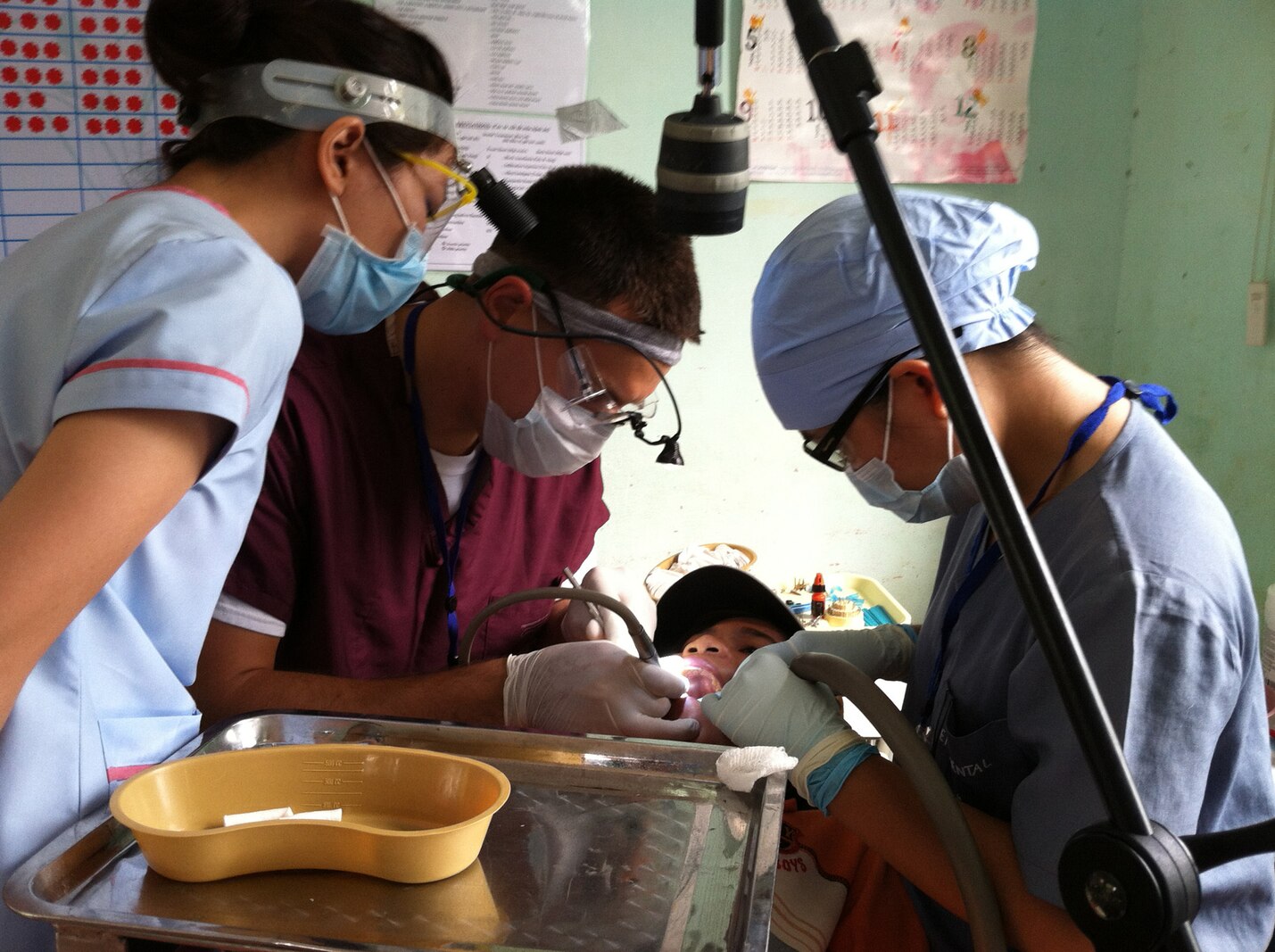 Navy Lt. Thomas V. Brislin, center, dentist and officer-in-charge with 1st Dental Battalion, 1st Marine Logistics Group, works 
alongside Vietnamese dental technicians from the East Meets West Non-Government Organization during Pacific Angel 2013. The NGO staff would often observe each dentist to learn new skills or to have discussions about techniques and materials.