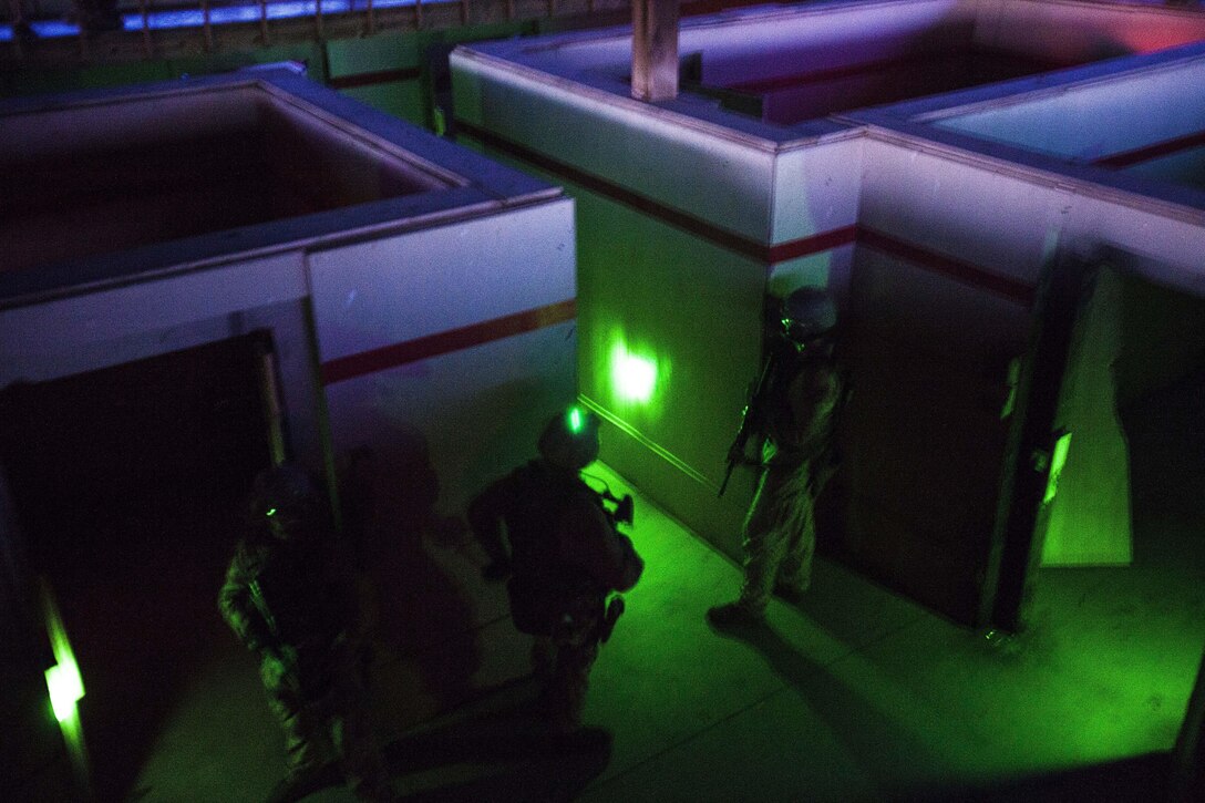 22nd Marine Expeditionary Unit force reconnaissance platoon Marines mark cleared rooms with green glow sticks while clearing a live-fire house during close quarters combat training at Tier 1 Group in Crawfordsville, Ark., June 30, 2013. The Marines completed more than 200 hours of advanced pistol, rifle, sniper, tactical driving, breaching and close quarters combat training throughout the 18-day course. (Marine Corps photo by Sgt. Austin Hazard/released)