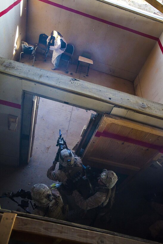 22nd Marine Expeditionary Unit force reconnaissance platoon Marines engage enemy role players in a live-fire house during close quarters combat training at Tier 1 Group in Crawfordsville, Ark., June 30, 2013. The Marines completed more than 200 hours of advanced pistol, rifle, sniper, tactical driving, breaching and close quarters combat training throughout the 18-day course. (Marine Corps photo by Sgt. Austin Hazard/released)