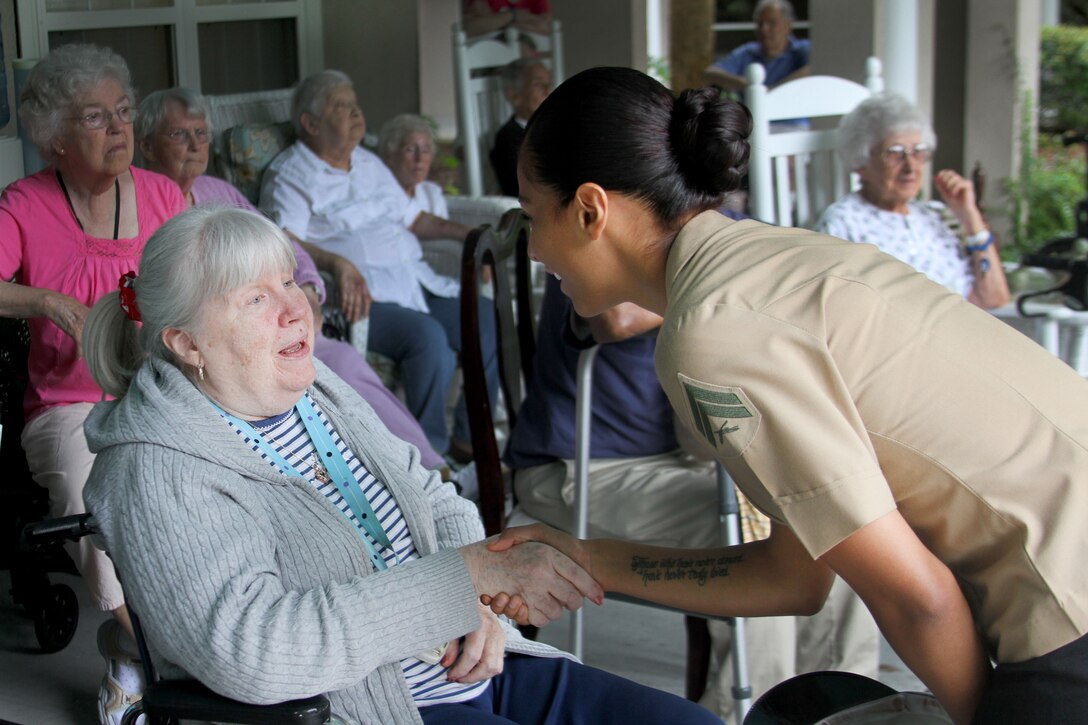 Corporal Gabrielle Bustos, a combat correspondent with the 6th Marine Corps District, speaks with a resident of the Bloom at Bluffton Home Care Center for the elderly in Bluffton, S.C., July 2, 2013.   Marines from the 6MCD and MCRD Parris Island volunteered to post the American flag at the care center, while spending quality time with its residents in spirit of the upcoming 4th of July holiday. (Official U.S. Marine Corps photo by Lance Cpl. John-Paul Imbody)                               