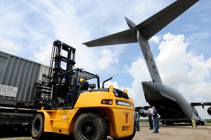 Sailors off-load oil spill containment equipment from a C-17 at Naval Air Station Joint Reserve Base (NAS JRB) New Orleans.  Air Force C-17s, from Anchorage, Alaska, delivered the equipment to support Deepwater Horizon oil spill response. Deepwater Horizon was an ultra-deepwater oil rig located 130 miles southeast of New Orleans that exploded April 20 and sank April 22, causing a massive oil spill threatening the U.S. Gulf Coast.  