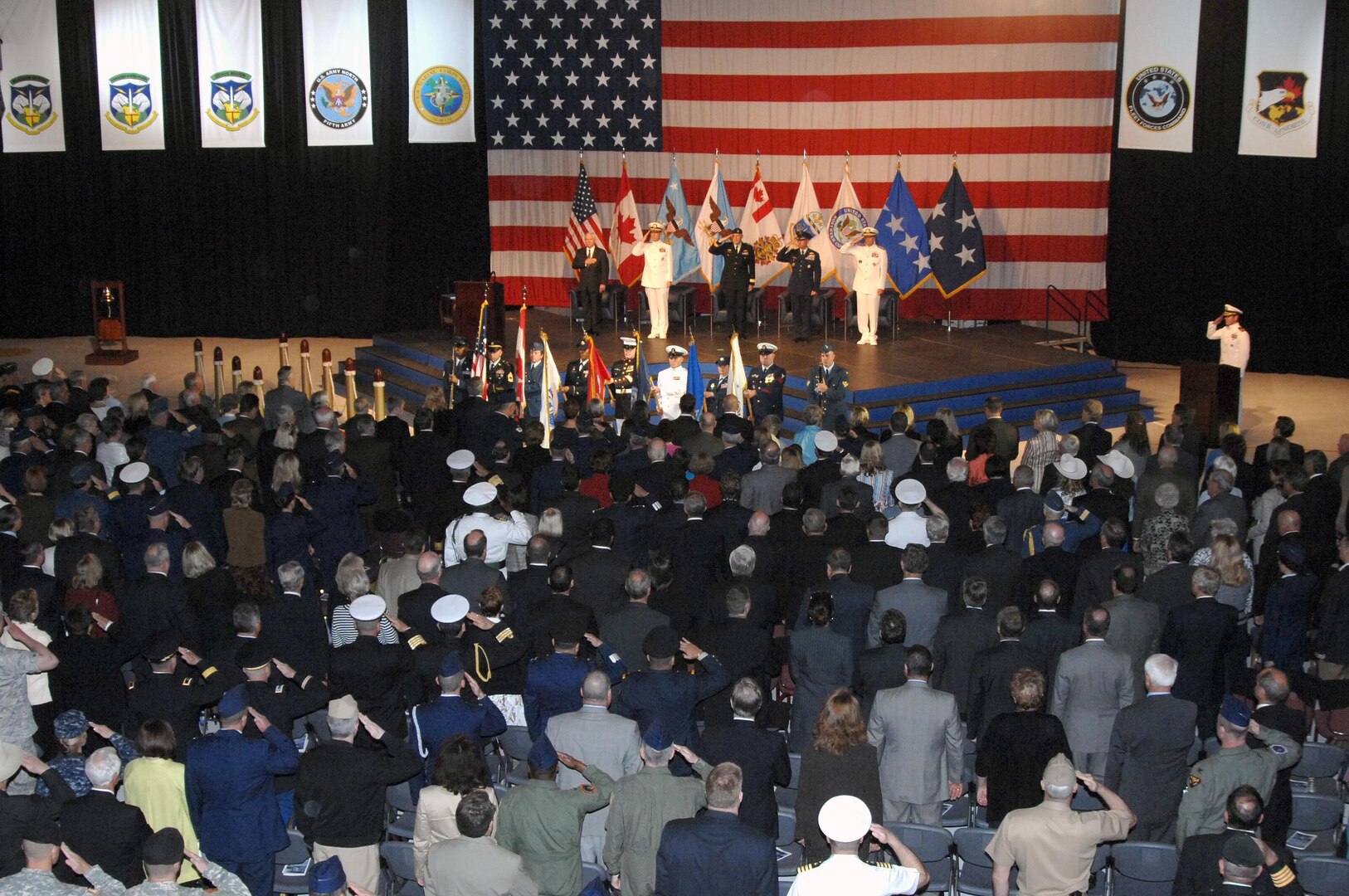 Members of the audience salute as the Canadian and U.S. national anthems are played at the North American Aerospace Defense Command and U.S. Northern Command change of command ceremony at Peterson Air Force Base, Colo., May 19. Navy Adm. James Winnefeld assumed leadership of the commands from Air Force Gen. Gene Renuart. 