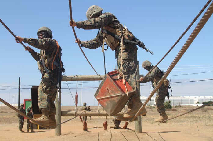 Recruits of Company C, 1st Recruit Training Battalion, work together to finisht the Two Line Bridge during the Crucible Confidence Course at Edson Range aboard Marine Corps Base Camp Pendleton June 25. The Cruicible Confidence Course focuses on teamwork. During the exrecise, drill instructors evaluate the recruit's performance.