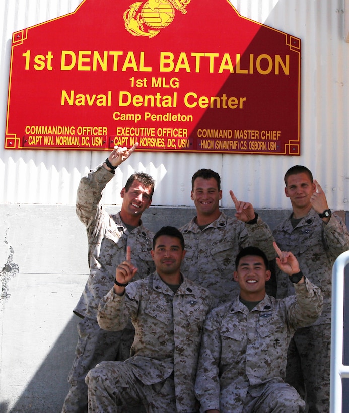 Top from left to right: Petty Officer 3rd Class Michael Conley, Petty Officer 3rd Class Joshua Fallick, and Petty Officer 3rd Class 
Justin Redus. Bottom from left to right: Petty Officer 3rd Class Erik Bryar, Petty Officer 3rd Class Albert Vu, all hospital corpsmen 
with 1st Dental Battalion, 1st Marine Logistics Group, and the winning team of the Corpsman Cup Challenge, pose in front of their 
unit’s sign.