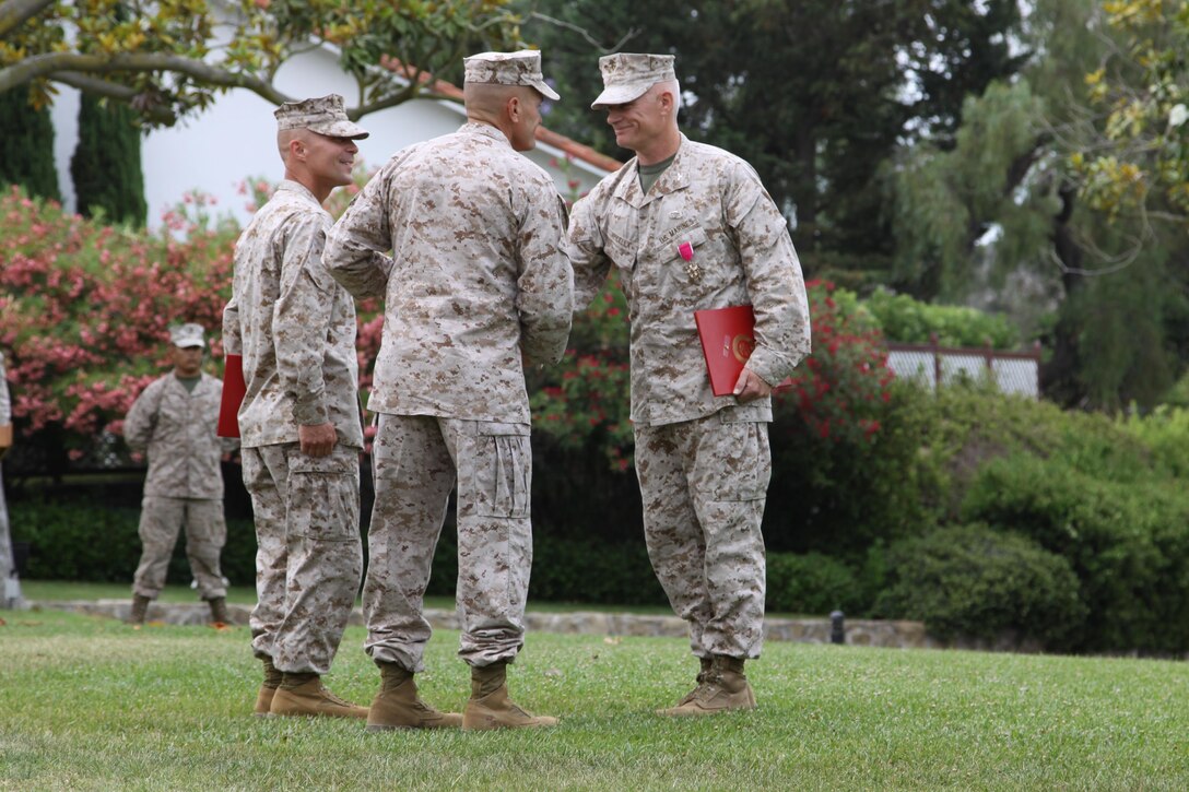 Camp Pendleton, Calif.- Col. Eugene N. Apicella is congratulated by Brig. Gen. Vincent A. Coglianese during his retirement ceremony held at the Ranch House here July 3. Apicella was commissioned a second lieutenant in December 1984 and served 28 years in the Marine Corps. During the ceremony Apicella was awarded a Legion of Merit gold star in lieu of second award. "I am absolutely thrilled to be here today as the official retiring officer," said Coglianese, base commanding general and regional authority for five Marine Corps installations in the Southwestern United States. "We are here to honor Eugene and Val for an outstanding 28 year career."