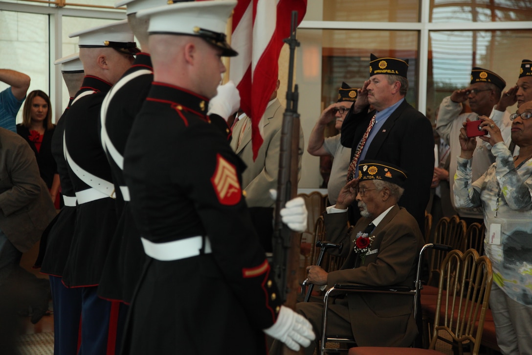Cpl. Deloyce McMurray, seated center, salutes the colors during a Montford Point Marine ceremony in which he was presented the Congressional Gold Medal July 2 at the Abraham Lincoln Presidential Library. McMurray enlisted in the Marine Corps in 1944 and was one of the few African Americans sent to the segregated Montford Point, North Carolina for basic training. McMurray was deployed to the Pacific during World War II seeing action during the battle of Iwo Jima. (U.S. Marine Corps photo by Cpl. Erik S. Brooks Jr./ Released)