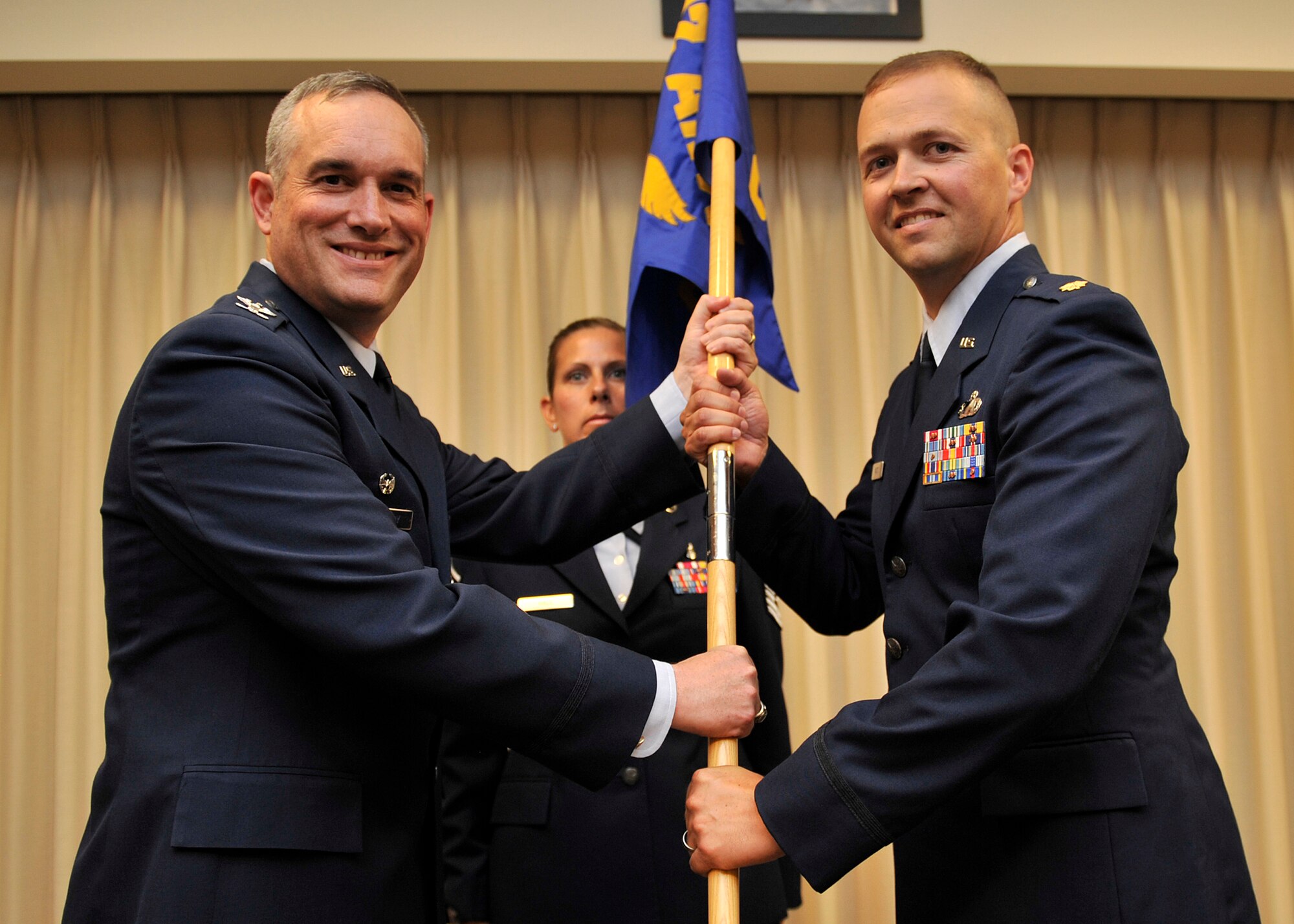 Col. Brian Newberry, 92nd Air Refueling commander, hands the unit guidon to Maj. Kevin Watts at Fairchild Air Force Base, Wash. July 3, 2013. Watts assumed command of the 92nd Comptroller Squadron. The change of command ceremony is a tradition that represents a formal transfer of authority and responsibility. (U.S. Air Force photo by Staff Sgt. Michael Means/Released)