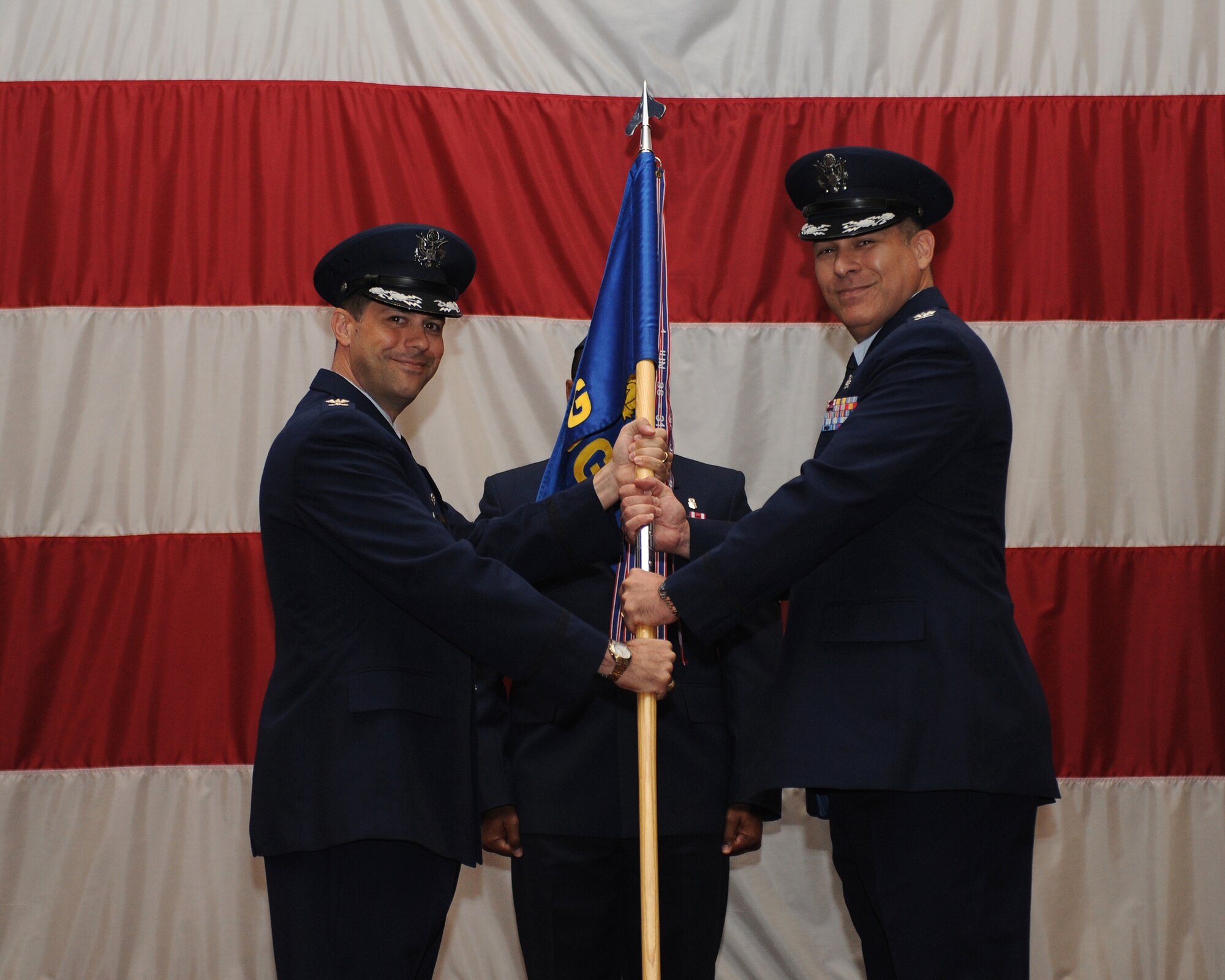 Col. Andrew Gebara, left, 2nd Bomb Wing commander, passes the 2nd Medical Group guidon to Col. Ender Ozgul, incoming 2nd MDG commander, during a change-of-command ceremony on Barksdale Air Force Base, La., July 3, 2013. Ozgul previously served as the deputy commander of the 31st Medical Group at Aviano Air Base, Italy. The change-of-command ceremony is a military tradition that gives service members the opportunity to witness their new leader's assumption of command. (U.S. Air Force photo/Airman 1st Class Benjamin Gonsier)
