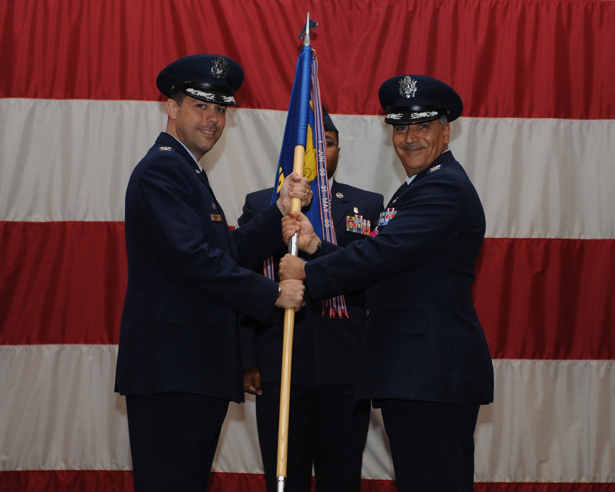 Col. Paul Fortunato, right, passes the 2nd Medical Group guidon to Col. Andrew Gebara, 2nd Bomb Wing commander, during a change-of-command ceremony on Barksdale Air Force Base, La., July 3, 2013. Fortunato held command of the 2nd MDG for three years. (U.S. Air Force photo/Airman 1st Class Benjamin Gonsier)
