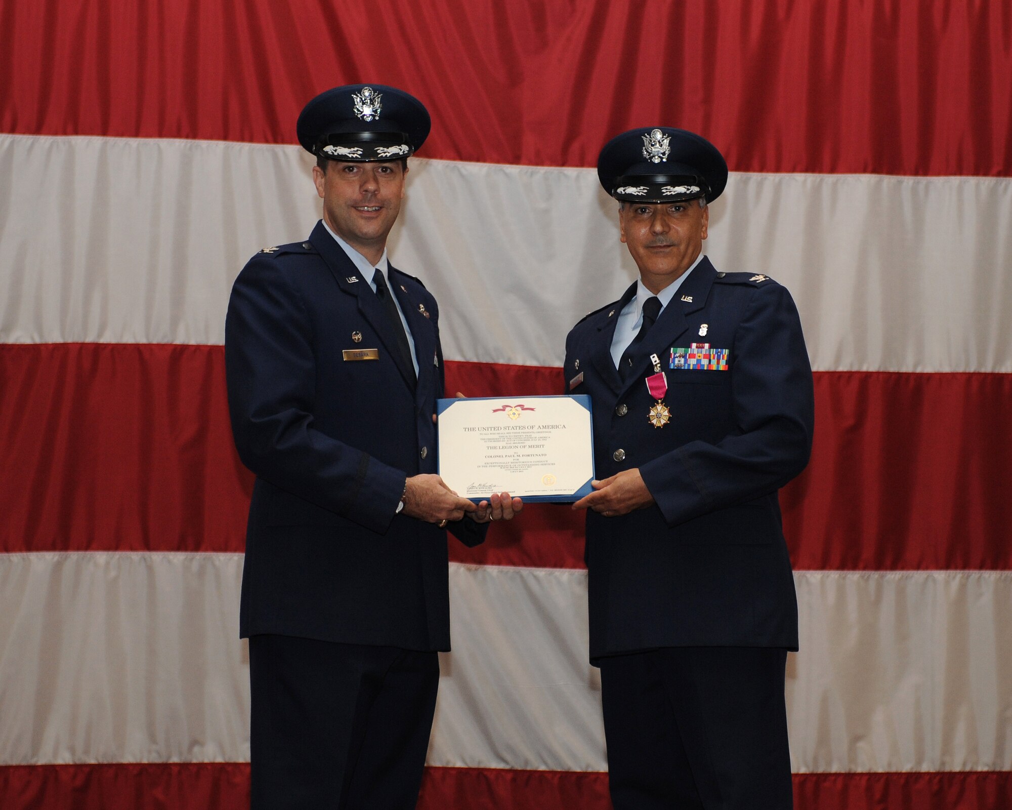 Col. Andrew Gebara, left, 2nd Bomb Wing commander, presents the Legion of Merit to Col. Paul Fortunato, outgoing 2nd Medical Group commander, during a change-of-command ceremony on Barksdale Air Force Base, La., July 3, 2013. Fortunato received the Legion of Merit for distinguishing himself through exceptionally meritorious conduct in the performance of outstanding service while in command of the 2nd MDG for three years. (U.S. Air Force photo/Airman 1st Class Benjamin Gonsier)