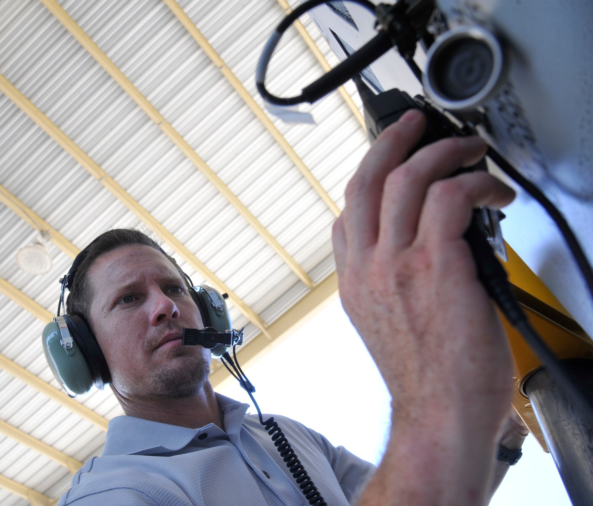 Master Sgt. Justin Johnston, 442nd Fighter Wing ground safety manager, tests the limits of a wireless communication system on an A-10 Thunderbolt II at Whiteman Air Force Base, Mo., June 26, 2013. The goal of the system is to improve communication while protecting the hearing of those who work around hazardous noises. (U.S. Air Force photo by Airman 1st Class Keenan Berry/Released)