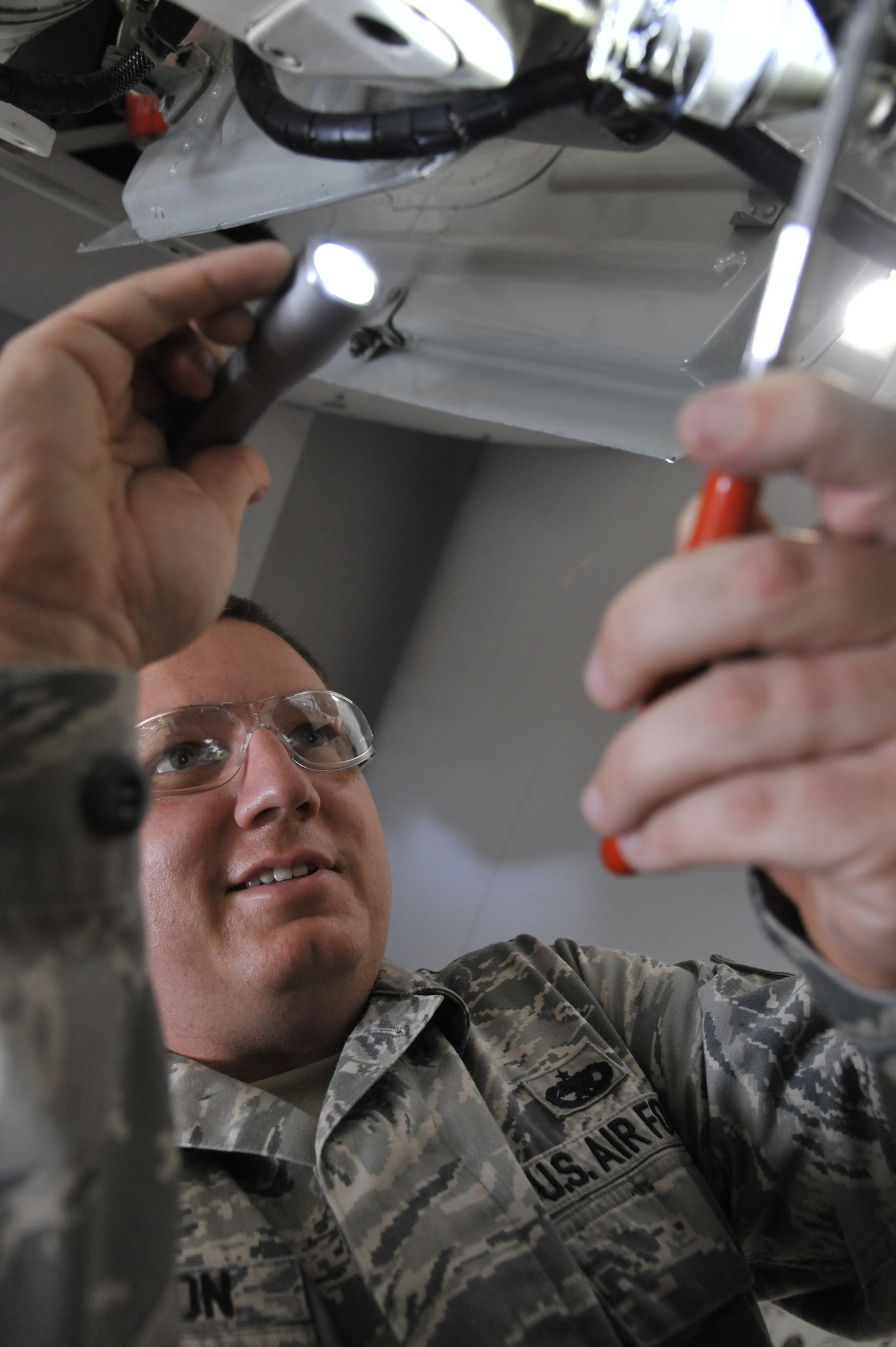 Tech. Sgt. Brandon Thompson, 442nd Maintenance Squadron phase dock coordinator, inspects a weight-on-wheels switch on the left main landing gear of the A-10 Thunderbolt II at Whiteman Air Force Base, Mo., June 11, 2013. This is a required inspection item, and ensures the drain hole is properly positioned. (U.S. Air Force photo by Airman 1st Class Keenan Berry/Released)