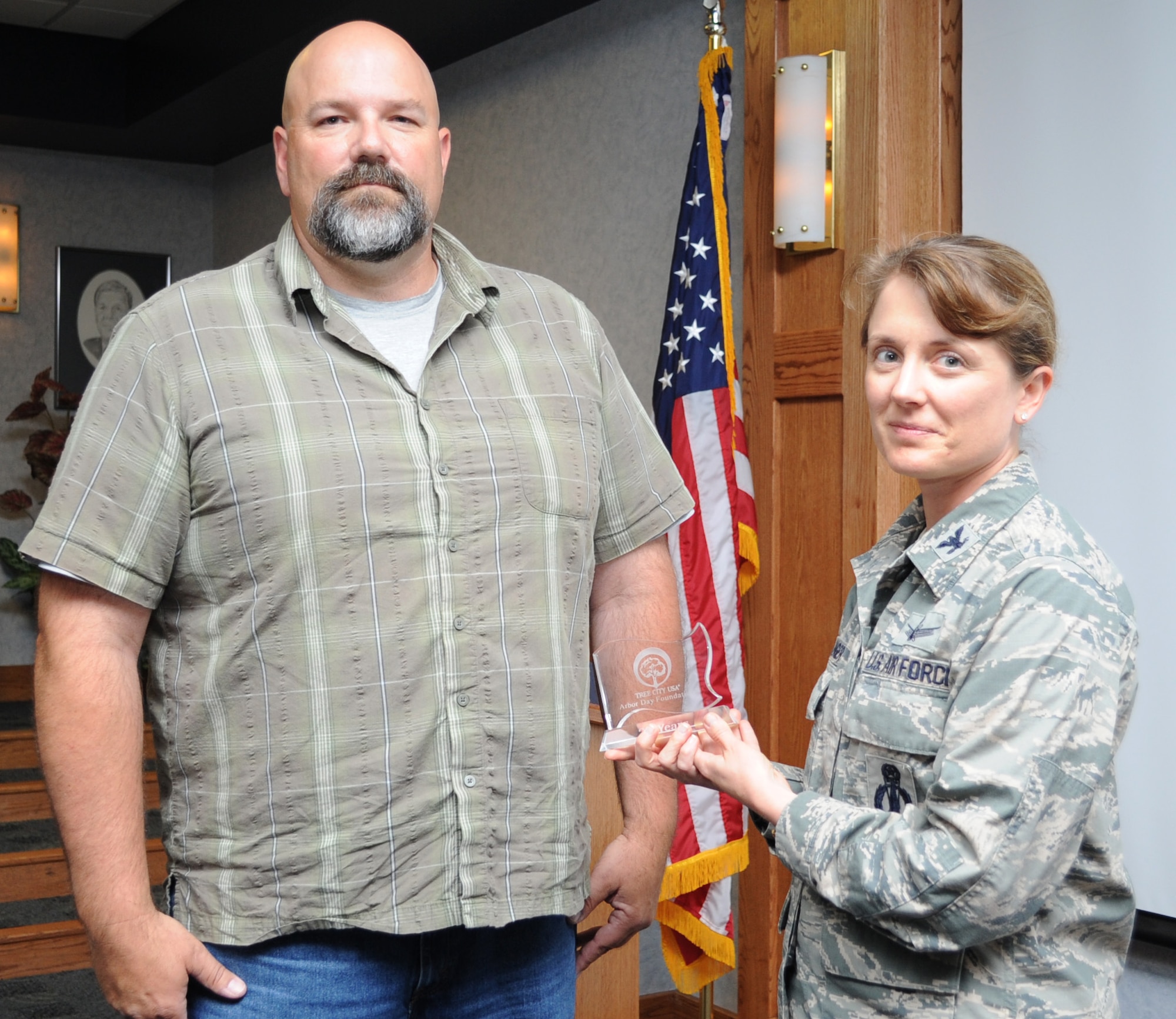 Dan Rogers, Department of Natural Resources and Conservation member, presents Col. Marné Deranger, 341st Missile Wing vice commander, with the 20th Anniversary Tree City USA Award during an Environment, Safety and Occupational Health council meeting on July 1. The award recognized Malmstrom Air Force Base for its excellence in urban forestry management. (U.S. Air Force photo/Senior Airman Katrina Heikkinen) 