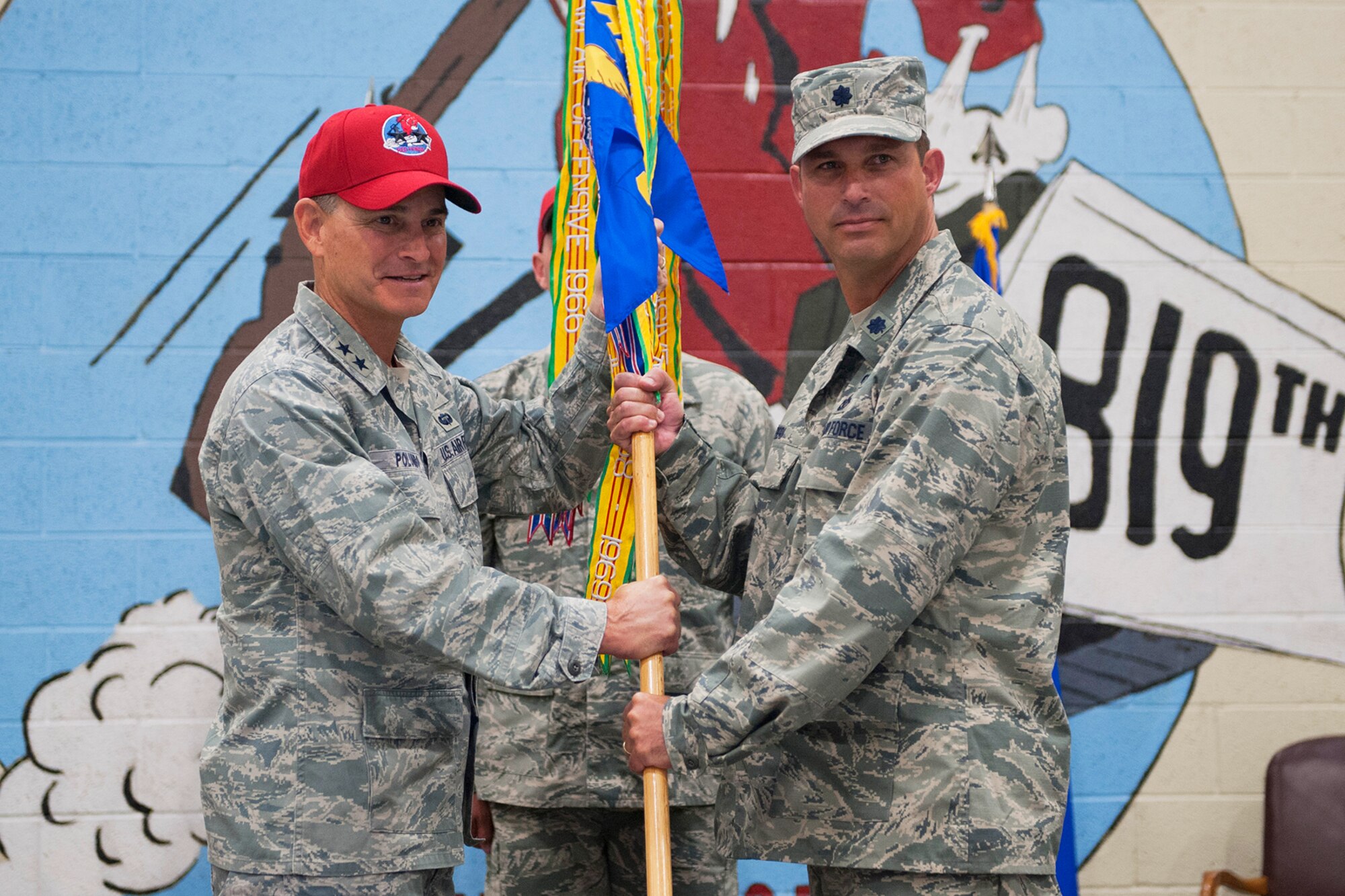 Lt. Col. Ronald L. Pieri, right, accepts command of the 819th REDHORSE Squadron from Maj. Gen. H.D. Polumbo Jr., 9th Air Force commander, on June 27 at the 819th RHS Airfields Hangar. Chief Master Sgt. William Valenti, 819th RHS chief of logistics, background, looks on. (U.S. Air Force photo/ Beau Wade)