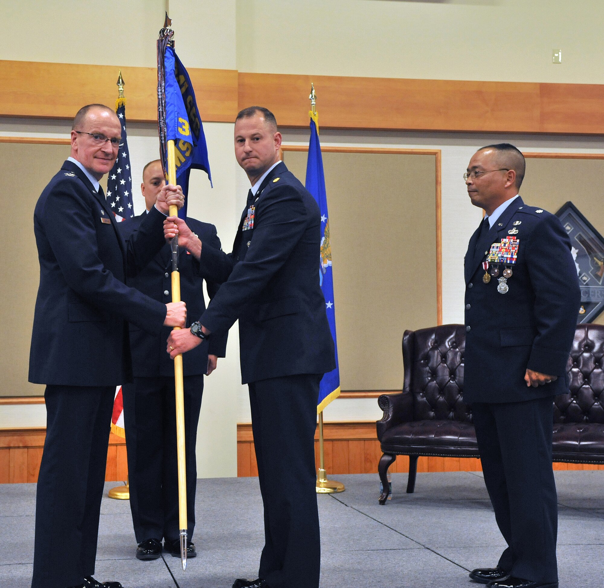 Maj. Justin Secrest, center, accepts command of the 341st Missile Security Forces Squadron from Col. David Lynch, 341st Security Forces Group commander, on June 25 at the Grizzly Bend.  Lt. Col. Steve Sugiyama, the relinquishing commander of 341 MSFS, right, looks on.  (U.S. Air Force photo/ John Turner)