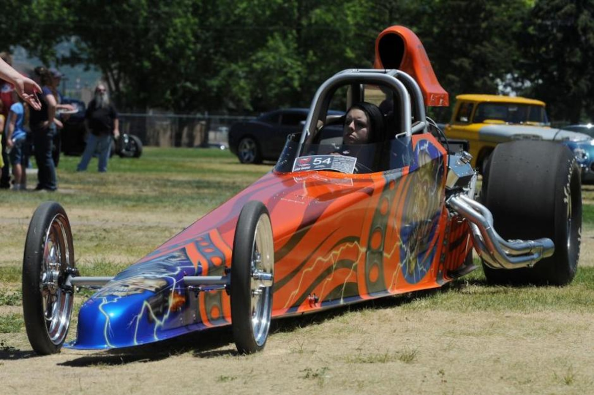 Ryann Thompson drives her father's dragster during the parade of winning cars at the 2013 Ogden Air Logistics Complex Car Show at Centennial Park. The 2002 dragster is owned by Daniel Thompson and won in the Best Modified Engine category. (U.S. Air Force photo by Alex R. Lloyd/Released)