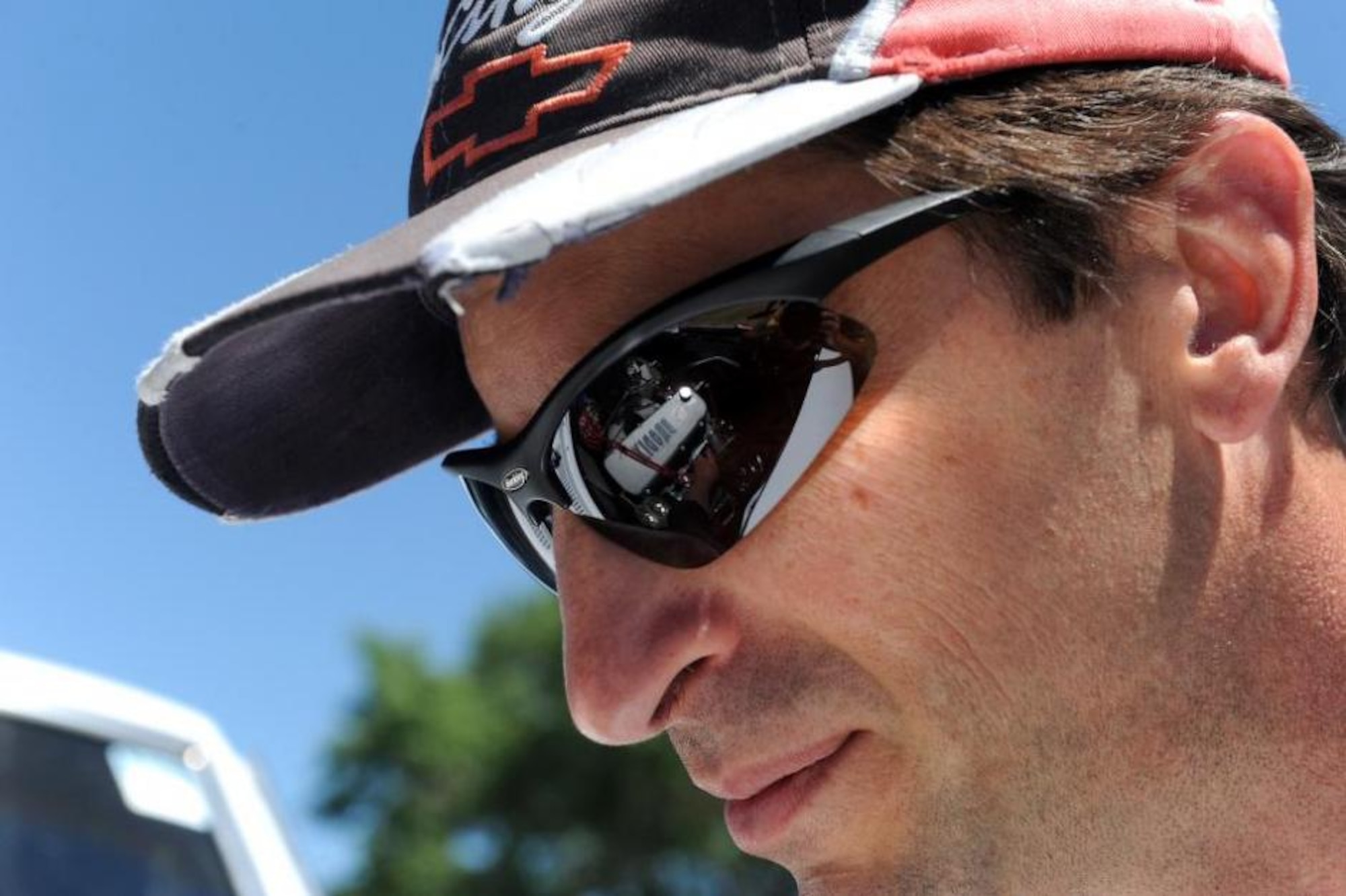 Johannes Berndt, of the Life Cycle Management Center, looks at the engine compartment of his entry into the 2013 Ogden Air Logistics Complex Car Show, a 1968 Chevolet Camaro, which he races. His sunglasses show a reflection of the 523 cubic BBC engine. (U.S. Air Force photo by Alex R. Lloyd/Released)