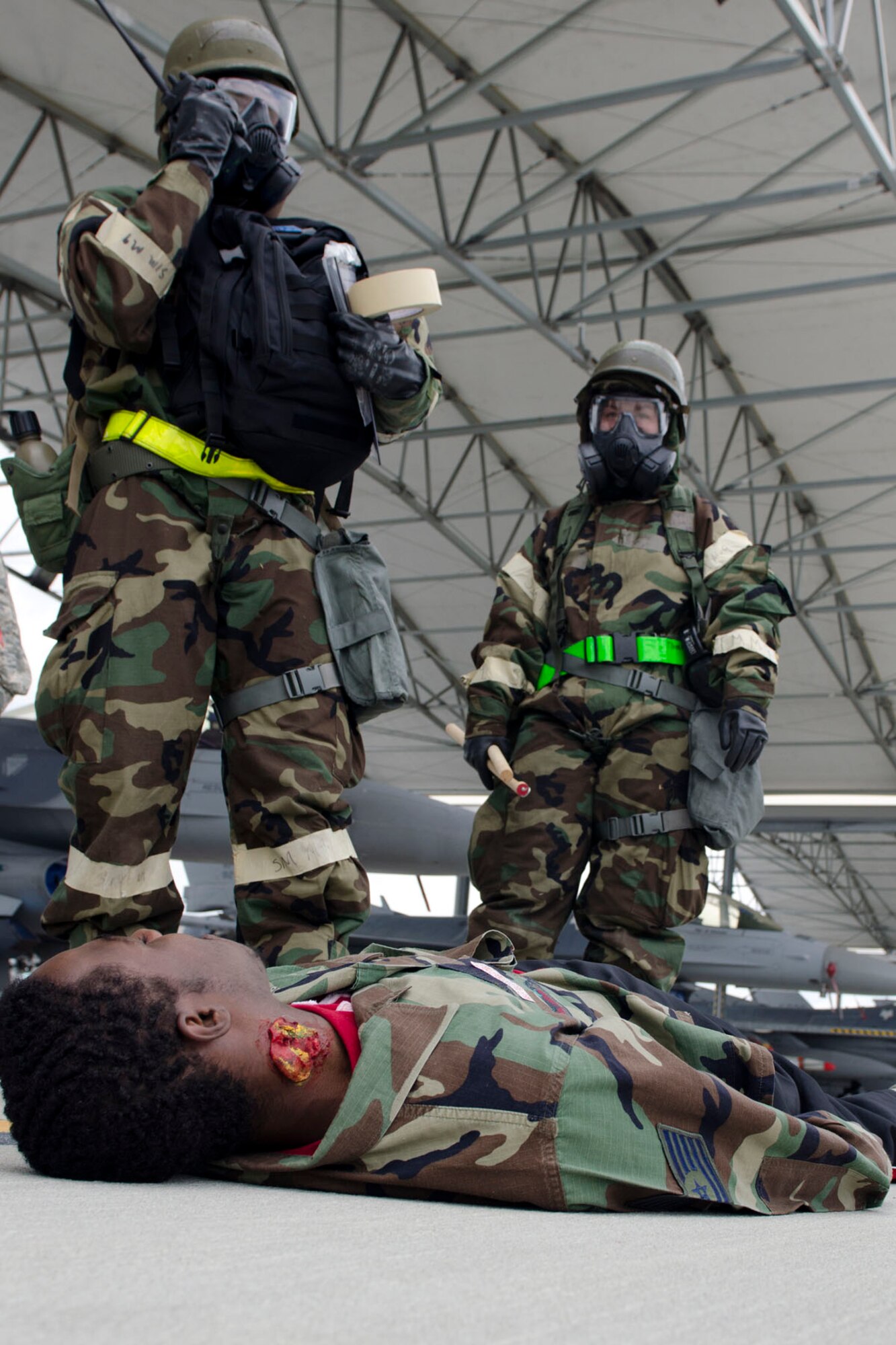 U.S. Air Force Lt. Col. Scott Bridgers, commander of the 169th Aircraft Maintenance Squadron, tends to the wounds of U.S. Air Force recruit Duwan Hester, a new South Carolina Air National Guard member assigned to the 169th Student Flight, during the 169th Fighter Wing Readiness Exercise, McEntire Joint National Guard Base, S.C., April 12, 2013. Members of the 169th Fighter Wing are preparing for a Phase I and II Readiness Inspection, which evaluates a unit's ability to deploy, then operate and launch missions in a chemical combat environment.  (U.S. Air National Guard photo by Staff Sgt. Jorge Intriago/Released)