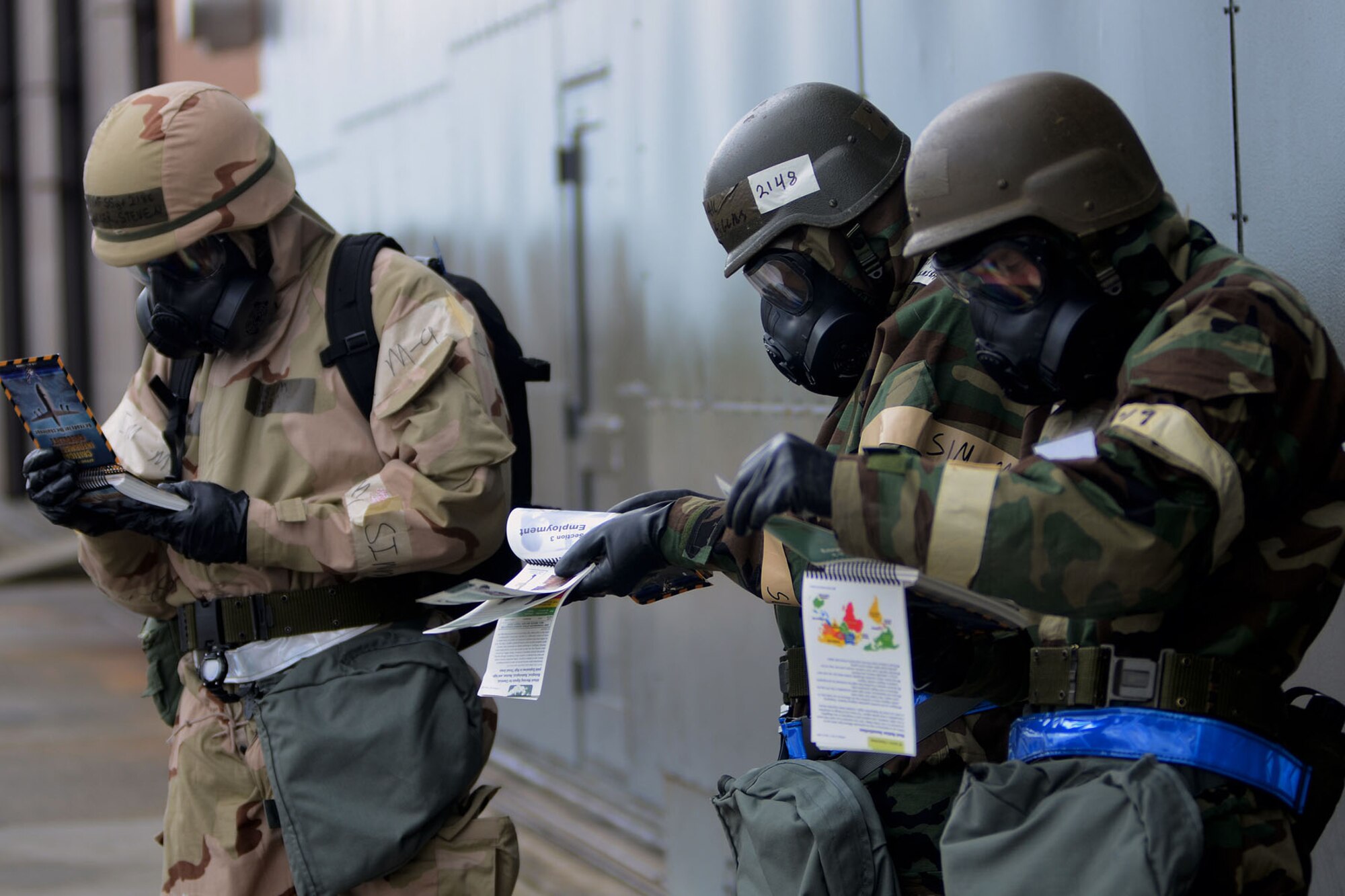 U.S. Air Force Airmen with the 169th Fighter Wing at McEntire Joint National Guard Base, S.C., read their Airman's Manual, while wearing full mission oriented protective posture gear, during a Phase II Readiness Exercise, April 12, 2013. Members of the 169th Fighter Wing are preparing for a Phase I and II Readiness Inspection, which evaluates a unit's ability to deploy, then operate and launch missions in a chemical combat environment.  
(U.S. Air National Guard photo by Tech. Sgt. Caycee Watson/Released)