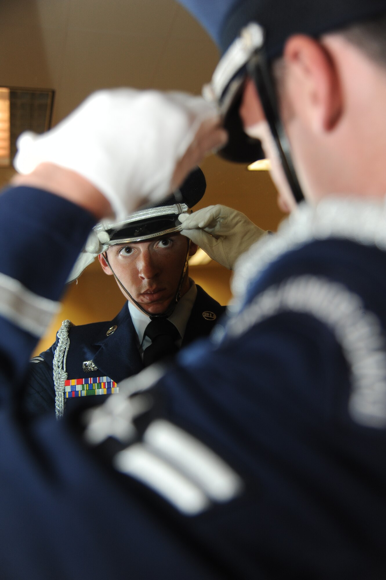 Airman 1st Class Nicholas Ong, Keesler Honor Guard, straightens his service hat prior to a training session June 26, 2013, at the Locker House, Keesler Air Force Base, Miss. The Keesler Honor Guard’s primary mission is to render military honors for our nation’s fallen service members.  They also support other ceremonial functions such as saber/sword cordons, parades, posting of the colors at retirements, change of commands, prisoner of war/missing in action honors, weddings, sporting events and venues within the local community.  (U.S. Air Force photo by Kemberly Groue)