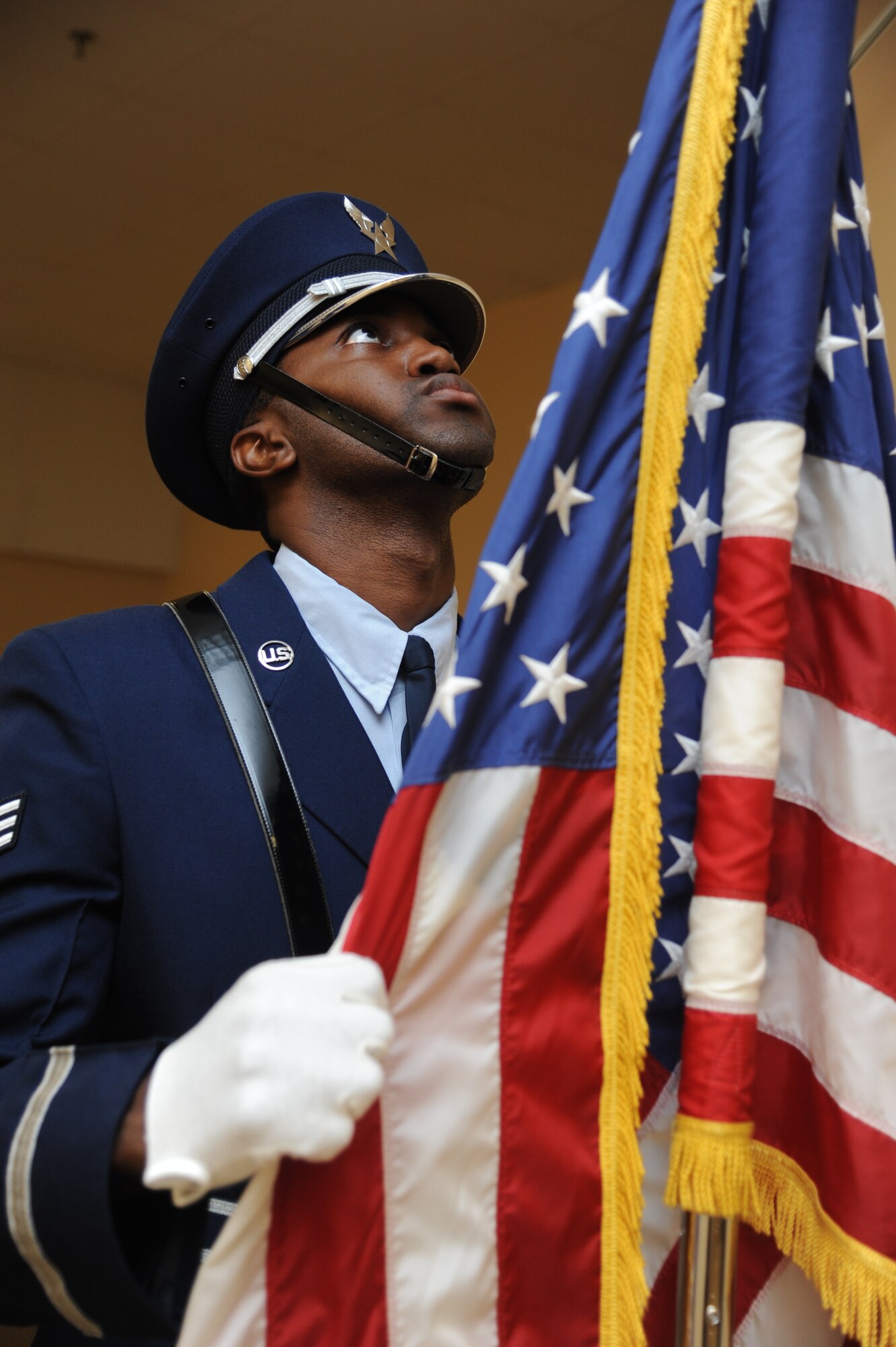 Senior Airman Deon Meadows, Keesler Honor Guard, straightens the American flag while he posts the colors during a training session June 26, 2013, at the Locker House, Keesler Air Force Base, Miss.  The Keesler Honor Guard’s primary mission is to render military honors for our nation’s fallen service members.  They also support other ceremonial functions such as saber/sword cordons, parades, posting of the colors at retirements, change of commands, prisoner of war/missing in action honors, weddings, sporting events and venues within the local community.  (U.S. Air Force photo by Kemberly Groue)